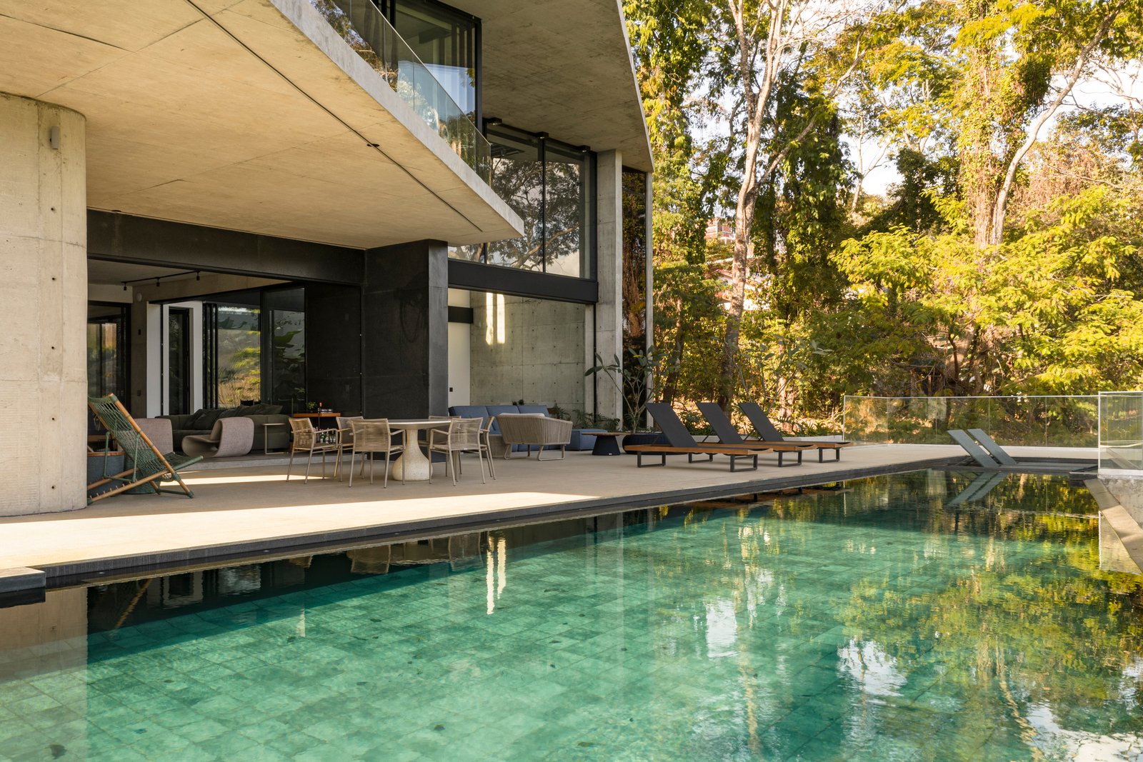 Casa moderna com piscina infinita e vegetação exuberante — projeto Casa Concreto, por dayala e rafael arquitetos associados, em Goiânia