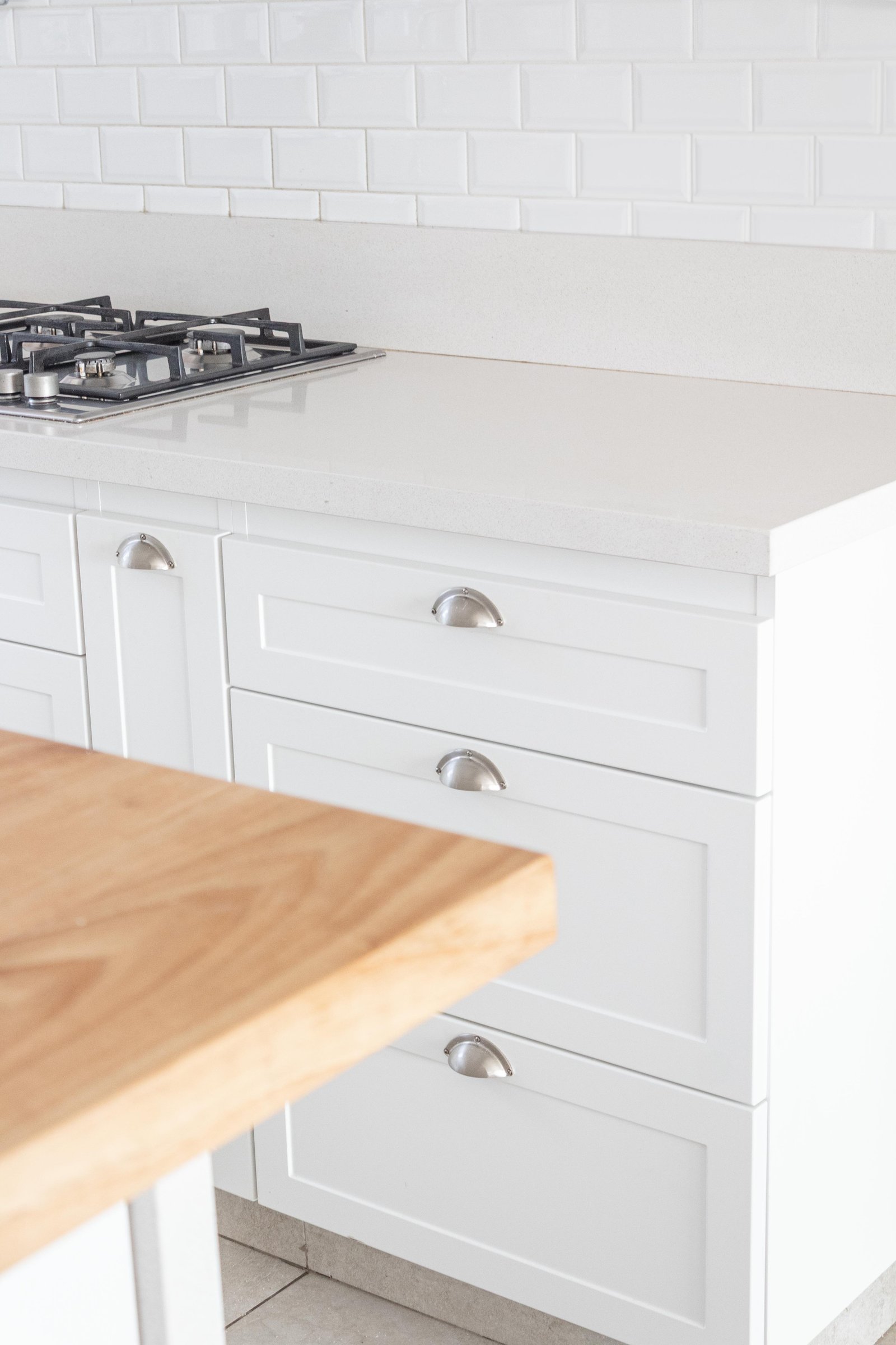 Cozinha moderna com ilha de madeira e bancada de quartzo branco — projeto San Rafael, por Catalina Fitero Fotografìa, em Blvd. de Todos los Santos 3500
