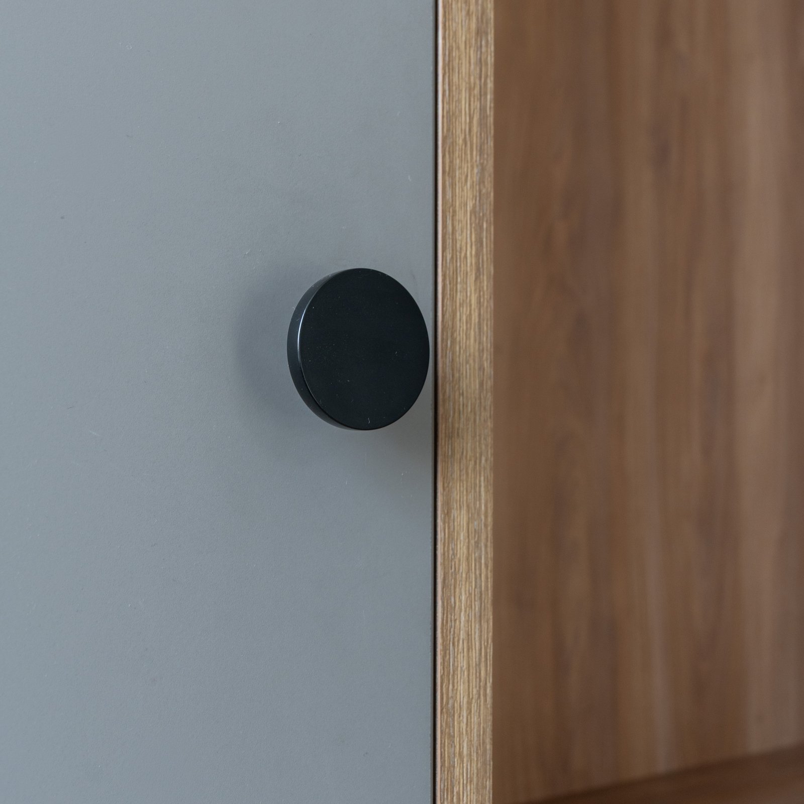 Detalle de mueble gris con tirador negro y madera natural — proyecto Castores - Estudio Gambotto, por ABEJA CONCEPT, en Los Castores