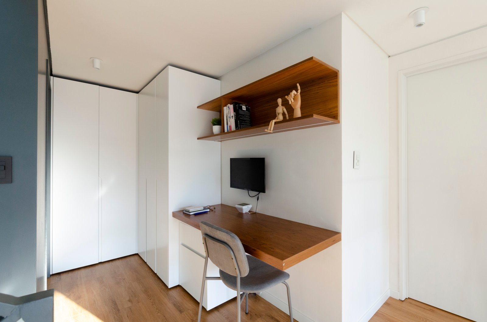 Escritorio moderno en L con almacenamiento integrado y silla — proyecto Guayra - Andrea Gonzales, por ABEJA CONCEPT, en Belgrano
