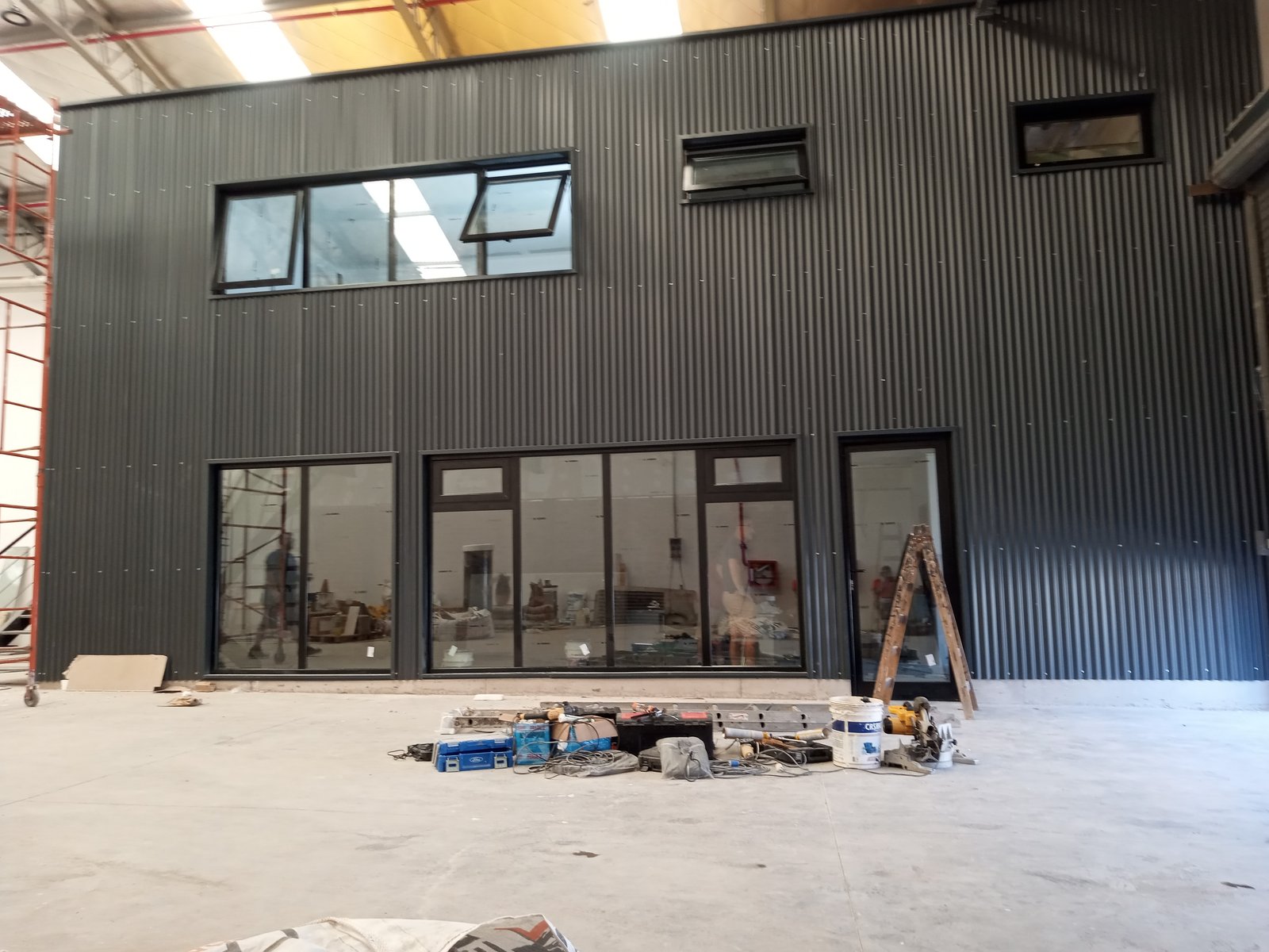 Fachada industrial de metal preto com grandes janelas, em construção — projeto Obra Mercedes Benz, por AberturasFortex, em Buenos Aires