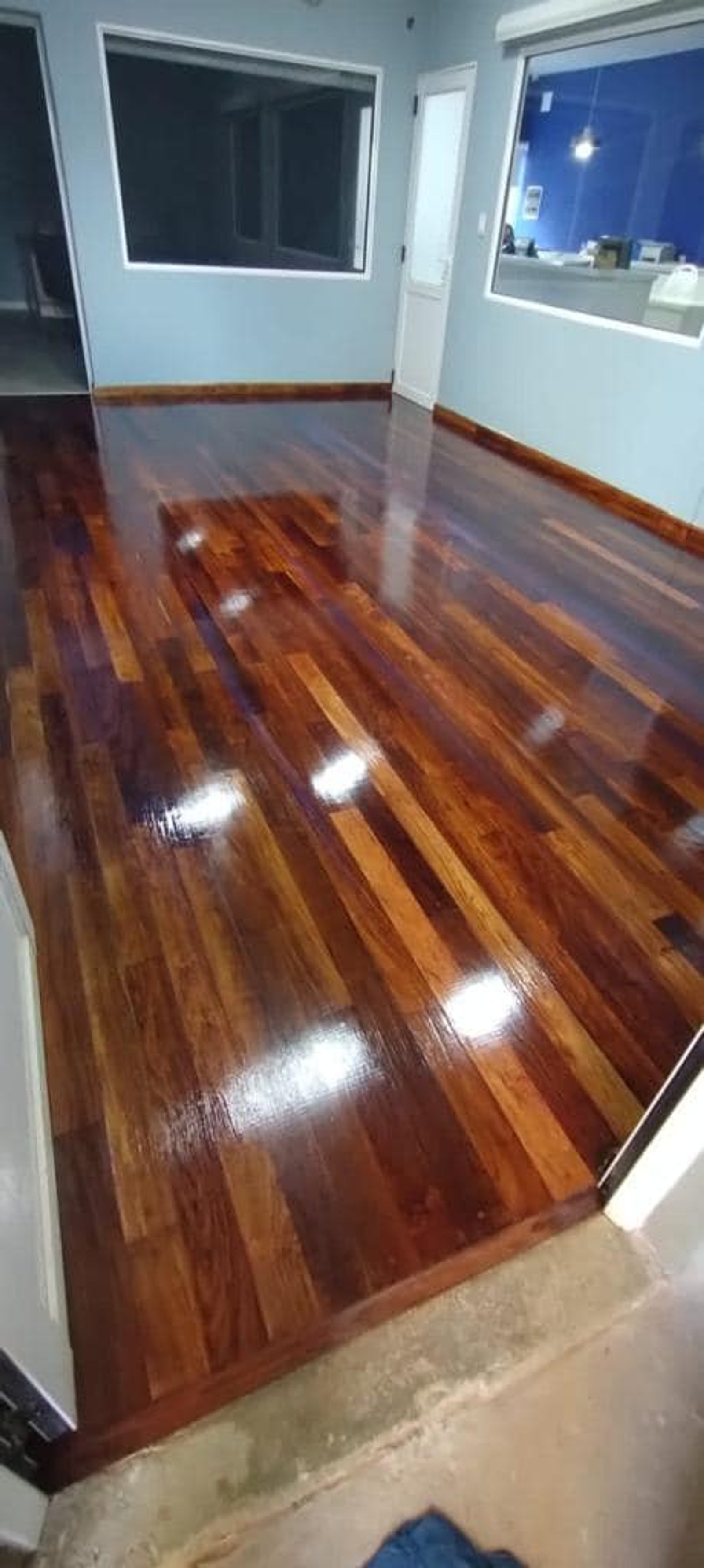 Piso de madera oscura brillante en un espacio comercial moderno — proyecto Esudio Contable, por Arquitecto Gustavo Maidana, en Caá Catí