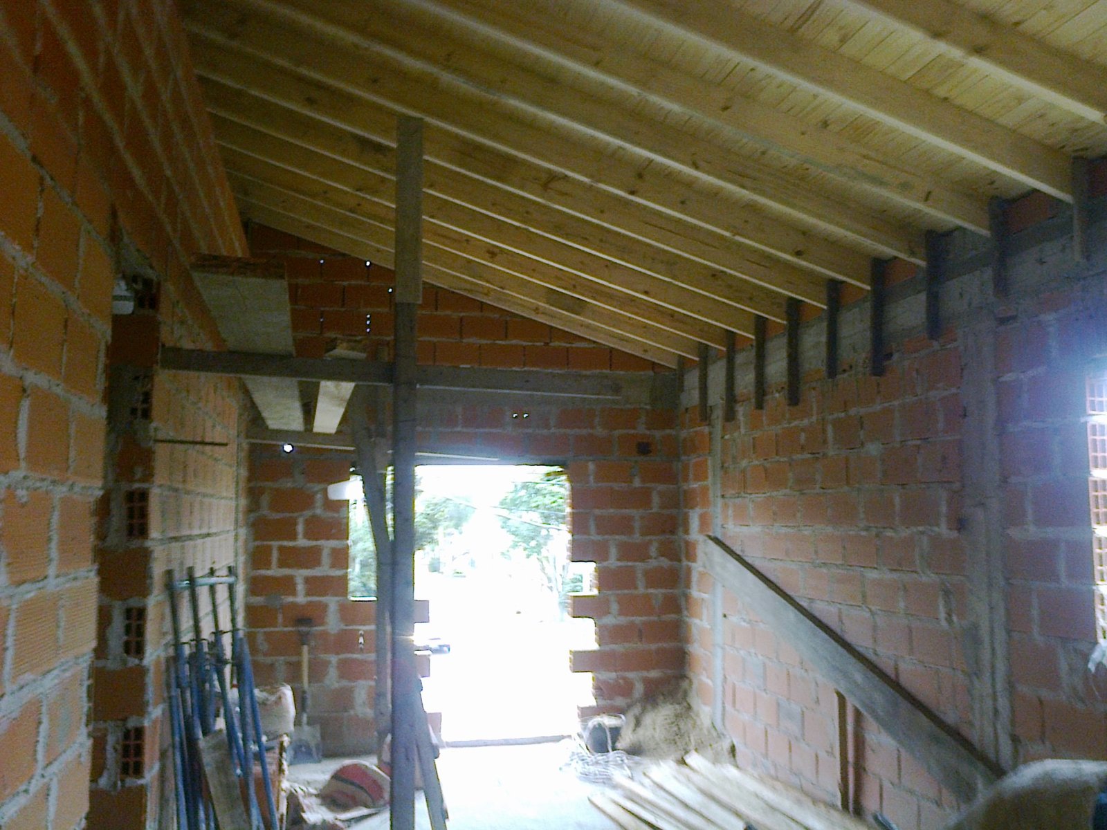 Interior de construcción con ladrillos expuestos y vigas de madera — proyecto Casa en Wilde, por Arquitecto Guido Niccoli, en Wilde
