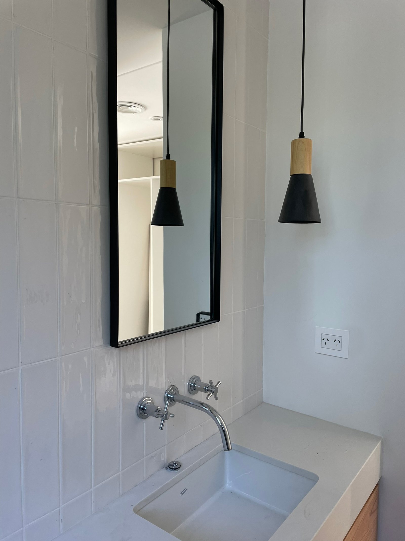 Banheiro escandinavo moderno com pendentes pretos e torneira cromada — projeto Casa MC, por Hermann Arquitectos, em Bv. Central