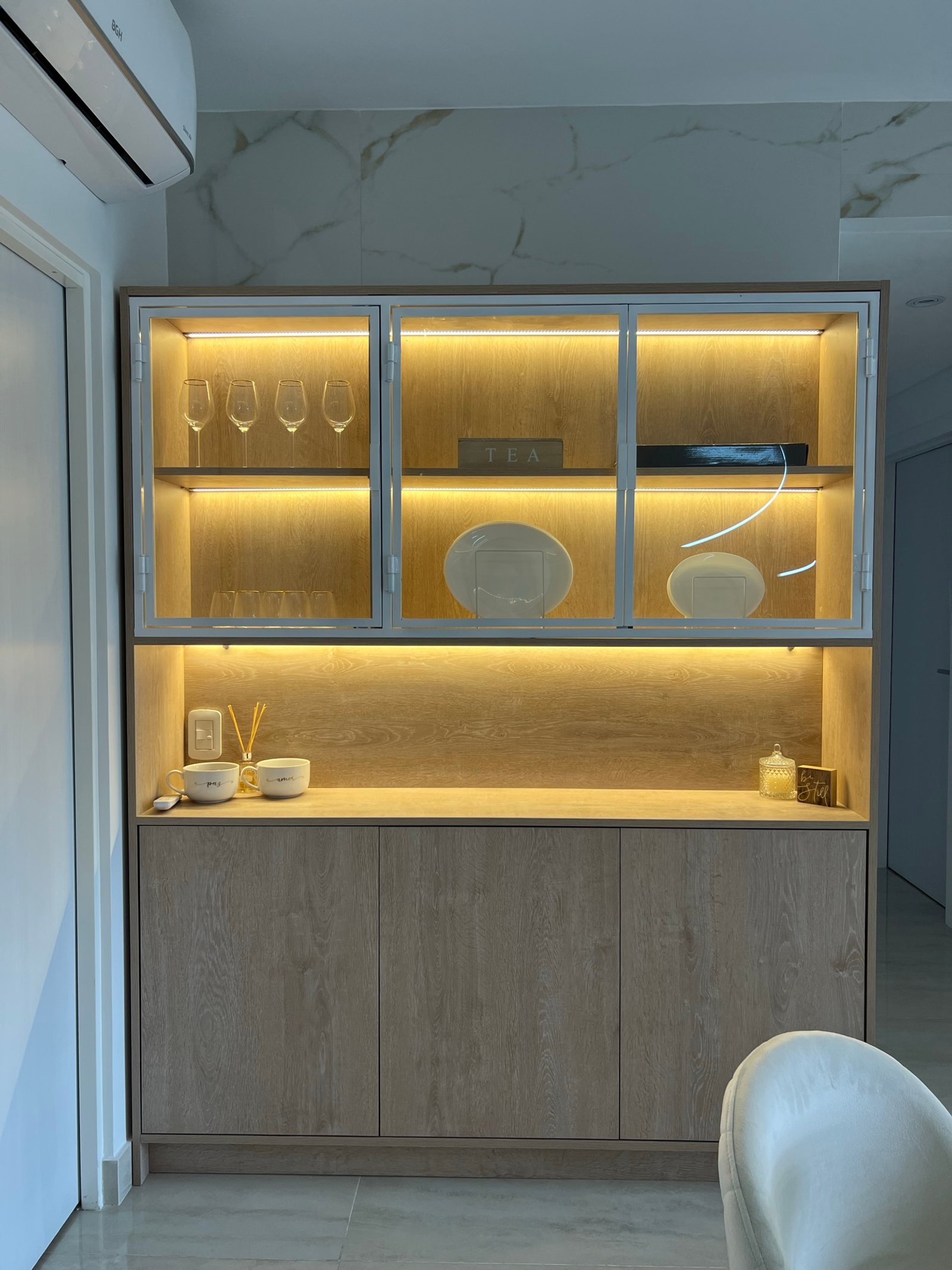 Mueble de guardado moderno con luces integradas y estantes de vidrio — proyecto Basualdo I, por MDBK Arquitectura, en Liniers