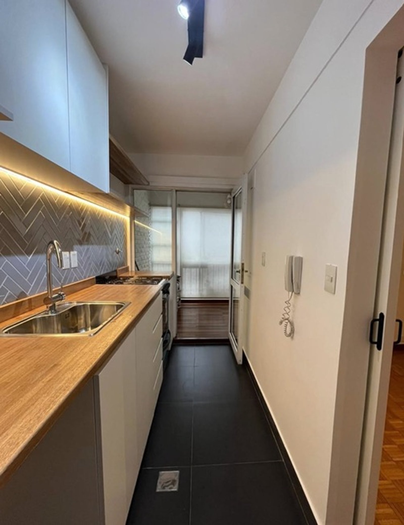 Cocina moderna con muebles blancos, encimera de madera y salpicadero de espiga — proyecto Migueletes , por Estudio NET Arquitectura , en Migueletes 1234