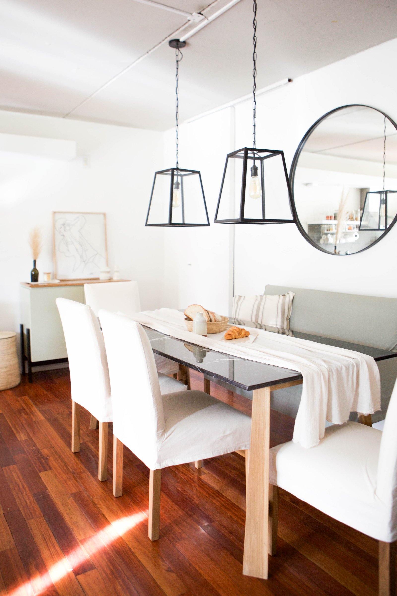Comedor moderno con luces geométricas y suelo de madera oscura — proyecto CAMI, por LACROZE DESIGN STUDIO, en San Isidro