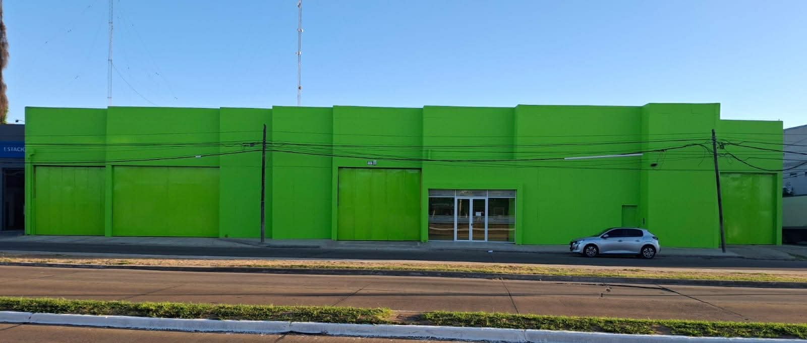 Fachada comercial verde brillante con paneles segmentados — proyecto Sucursal Via Cargo, filial Corrientes, Empresa de distribución y logística., por Arquitecto Gustavo Maidana, en