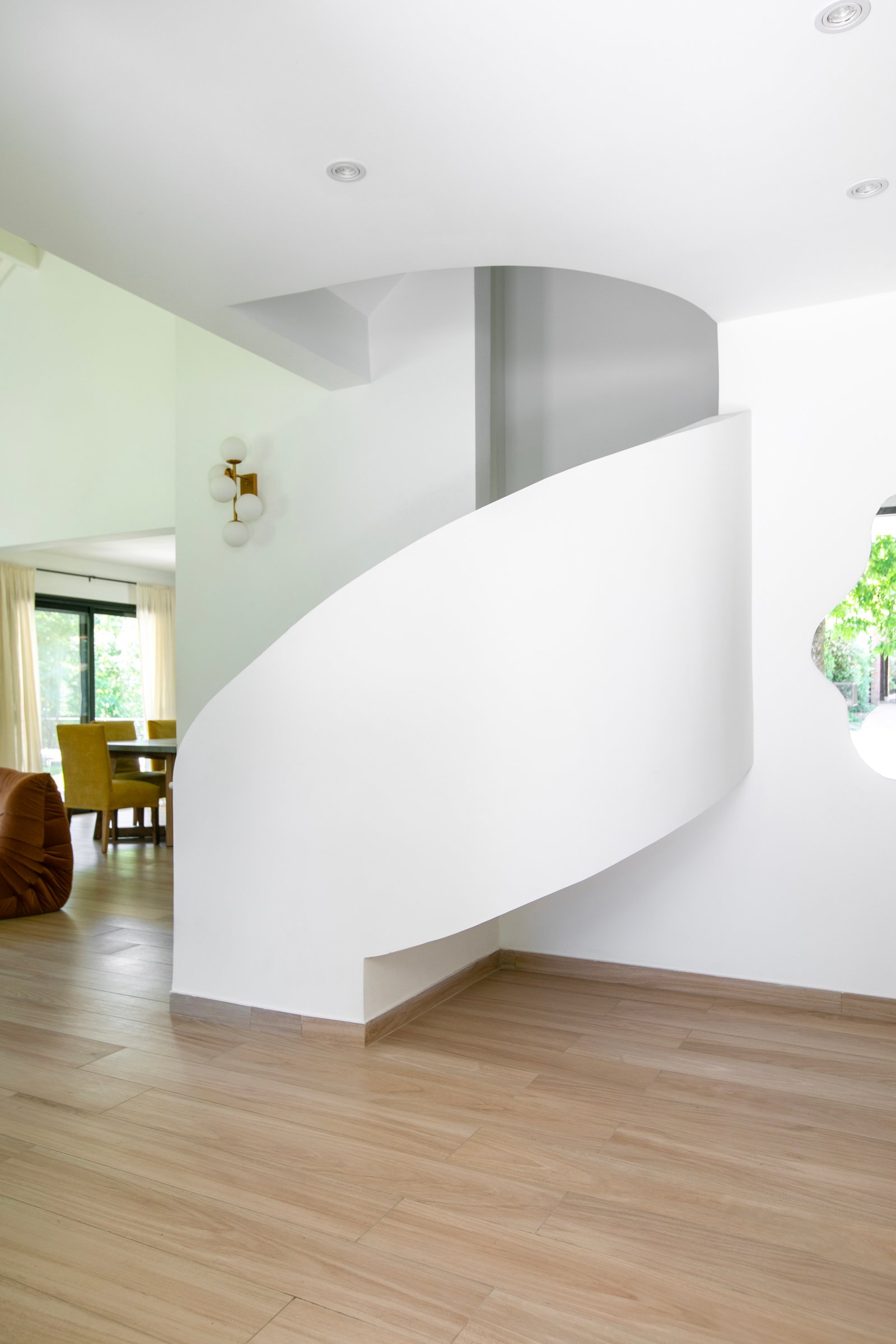 Escalera caracol moderna de pared curva, suelo de madera — proyecto PROYECTO CAT COURREGES, por ILVA, en Provincia de Buenos Aires
