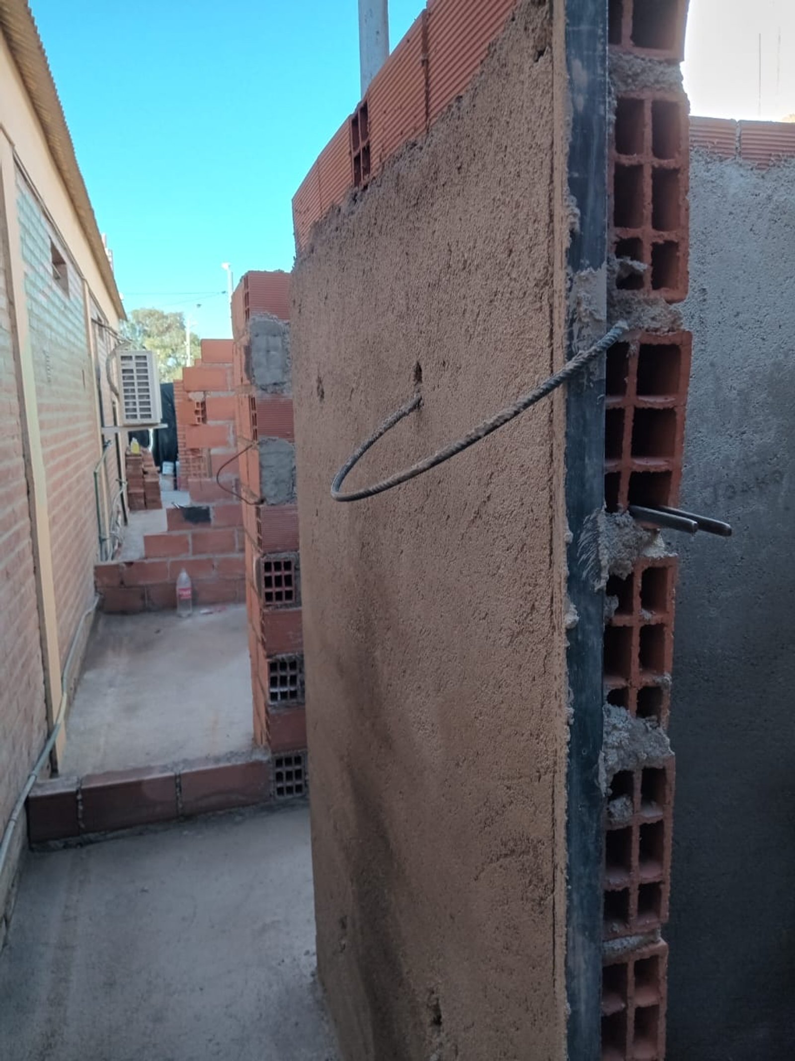 fachada en construcción con revoque y ladrillos a la vista — proyecto confiteria vieja estacion, por Diego ceballos, en Merlo