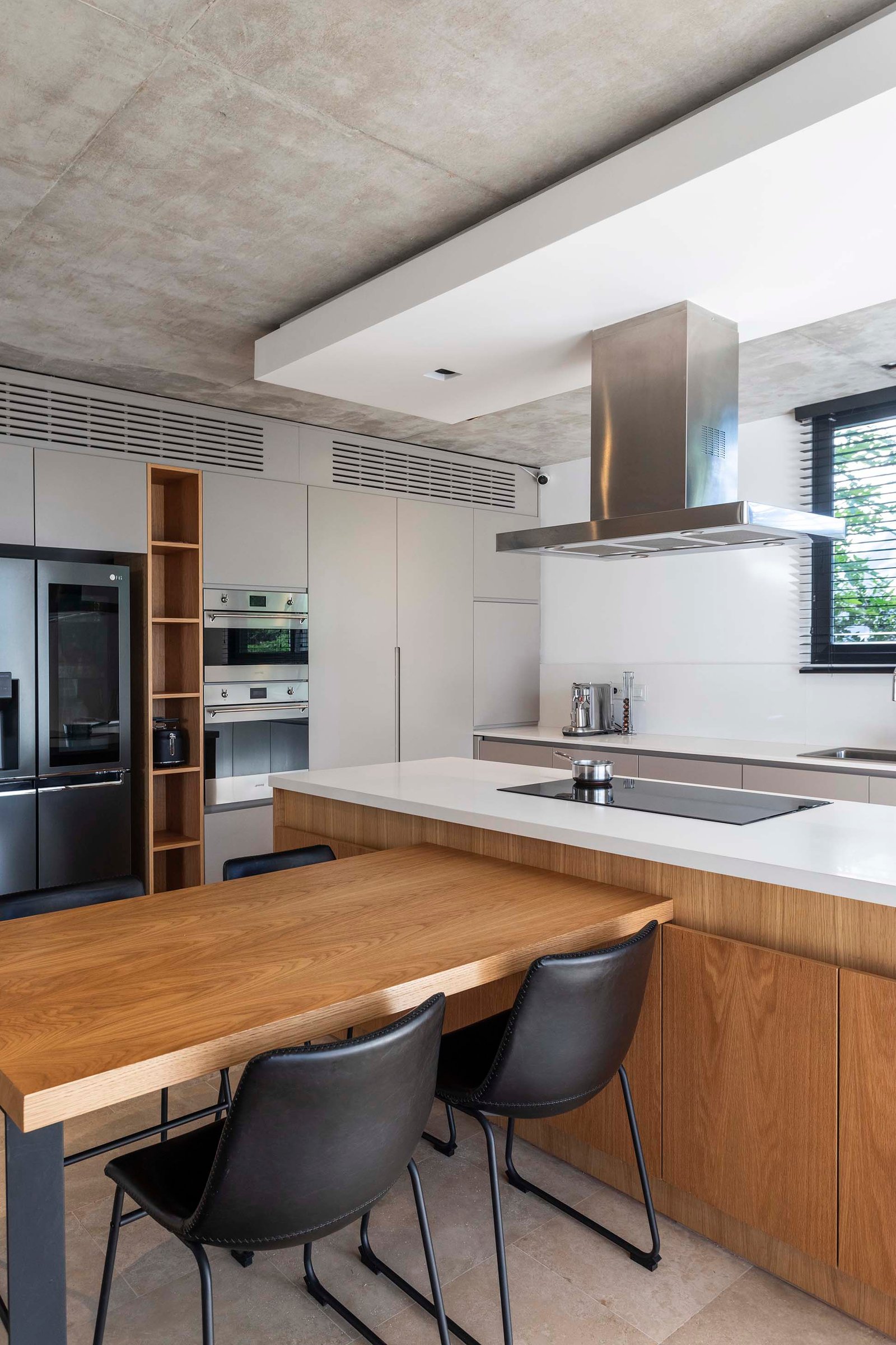 Cocina moderna industrial con isla, techo de hormigón y comedor integrado — proyecto Serra Golf - Estudio Remy, por ABEJA CONCEPT, en Avenida del Golf s/n