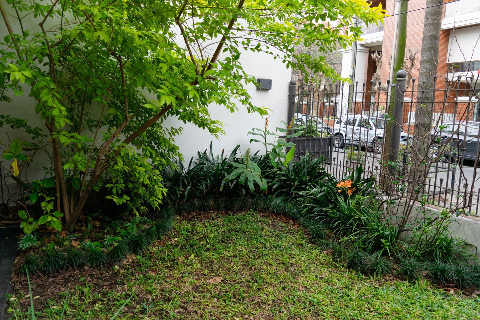 Patio moderno con pared verde exuberante y suelo de piedra — proyecto Proyecto Moreno, por Greenwood Paisajismo, en Moreno 419