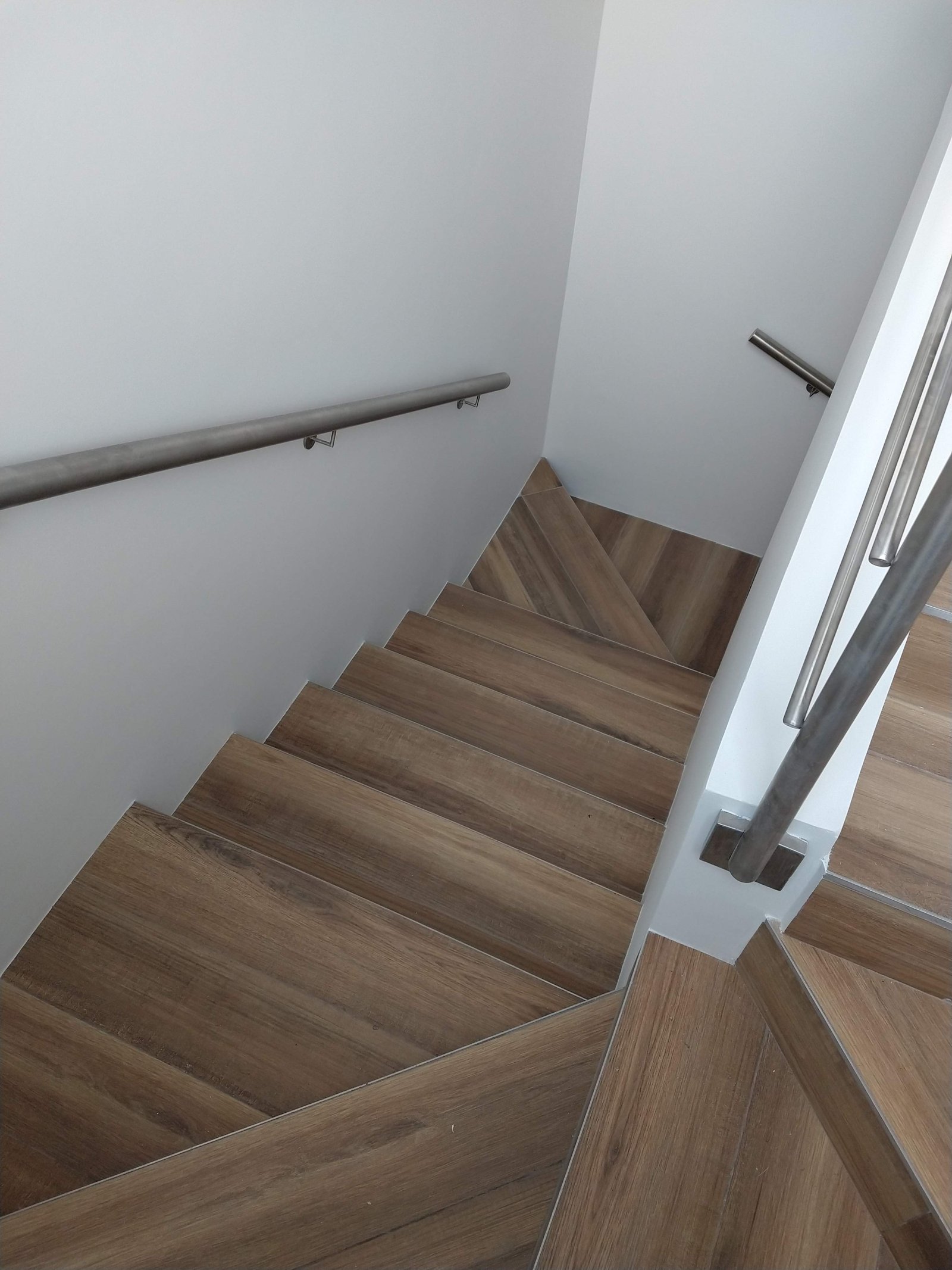 escalera flotante moderna con peldaños de madera y barandilla metálica — proyecto Proyecto A-F, por TERROC, en Luján de Cuyo