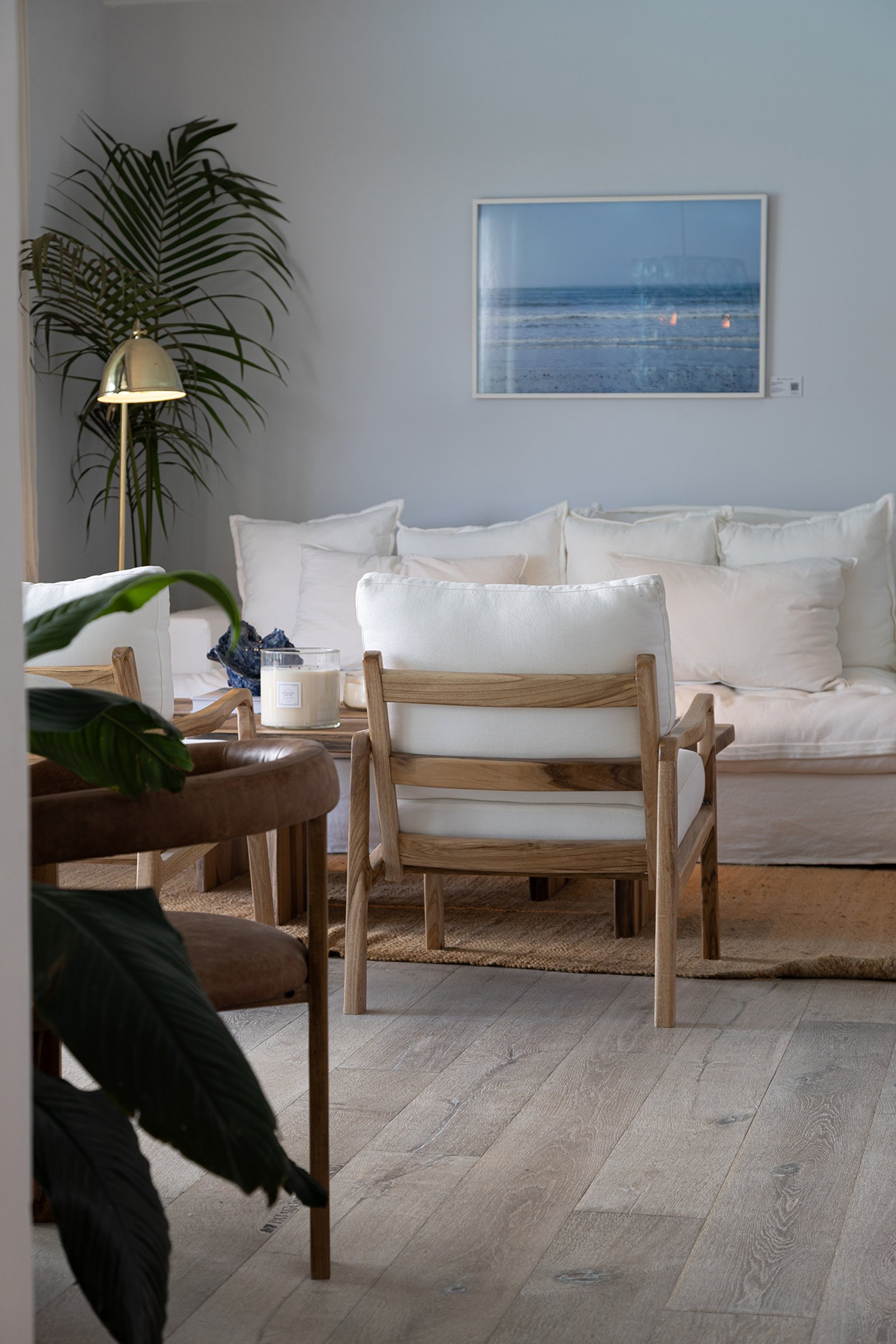 Sala de estar escandinava con sofá blanco, sillón de madera y cuadro de mar — proyecto Ivan Nahas, por Gaby Alfonso, en B1648 Tigre
