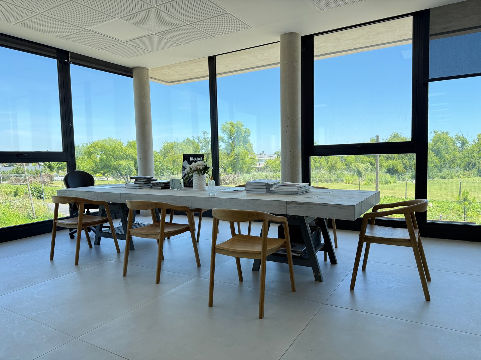 Escritório moderno com janelas amplas e mesa longa — projeto Showroom, por GAP HAUS, em Calle Austria Nte. 2450