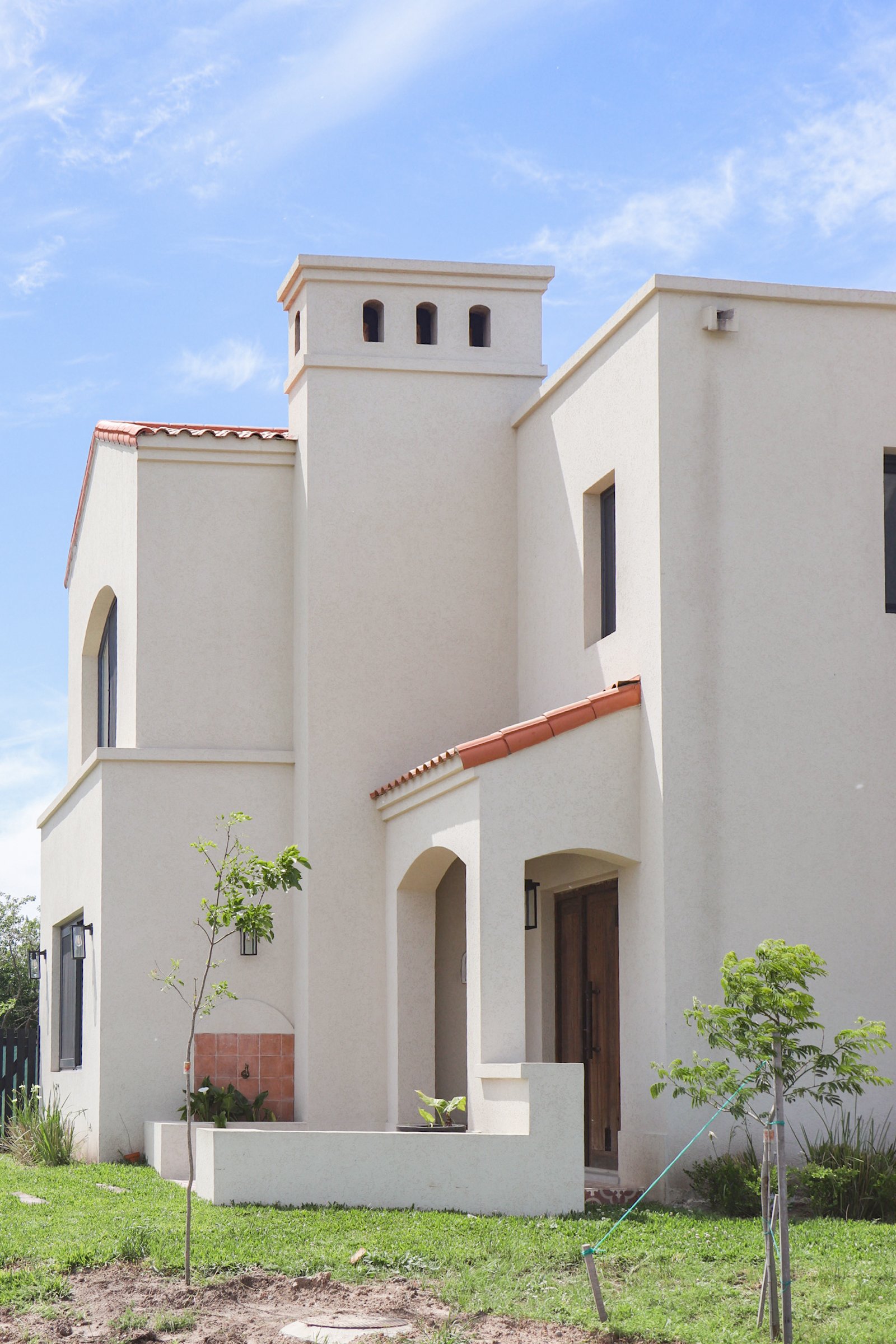 Fachada de casa blanca estilo mediterráneo moderno — proyecto Casa San Fermin 200, por R+B arquitectos, en Pasteur 662