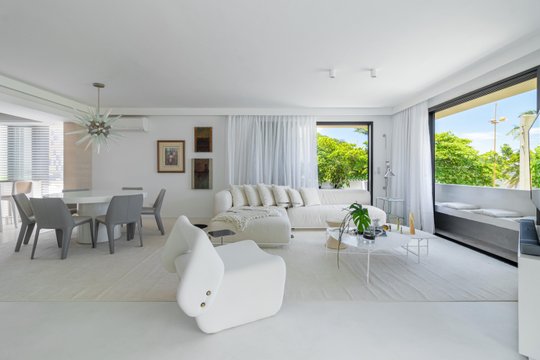 Amplio living comedor blanco con sofa curvo modular y vistas tropicales — proyecto Residencial, por  Rodolfo Fontana