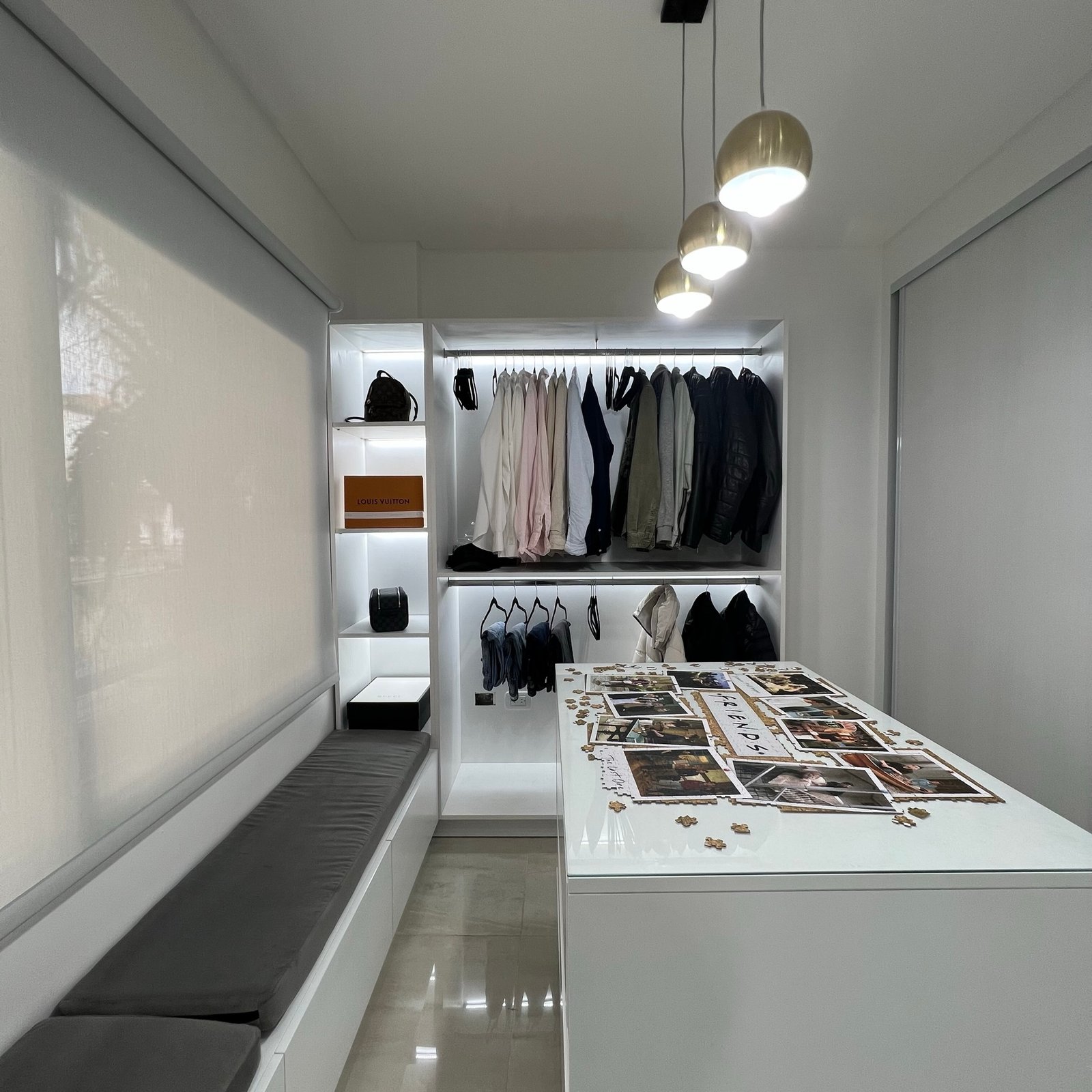 Interior de vestidor moderno con isla y banco incorporado — proyecto Basualdo I, por MDBK Arquitectura, en Liniers