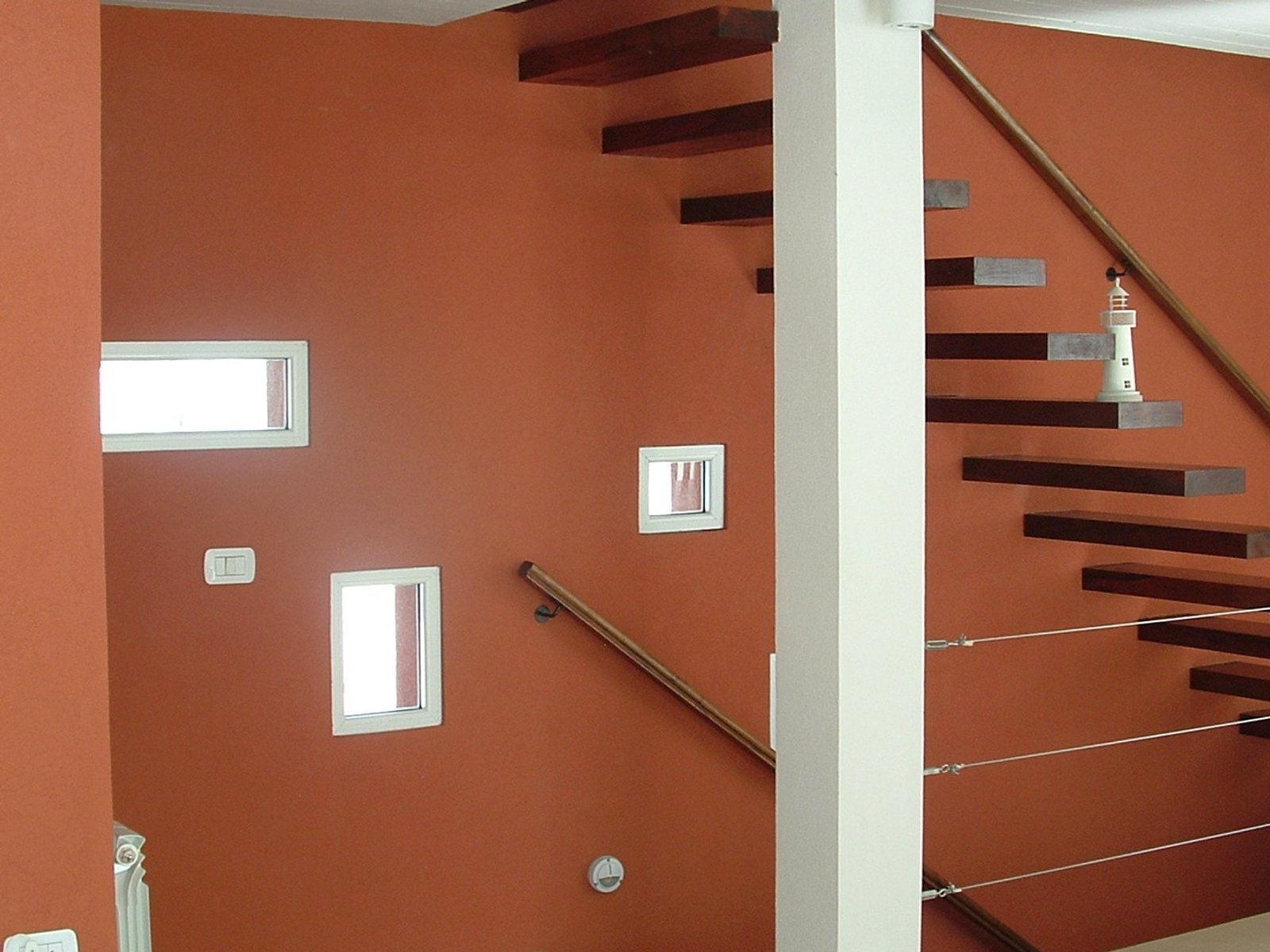 escada flutuante moderna com paredes terracota — projeto villa del puente, por GJF estudio, em Costa del Este