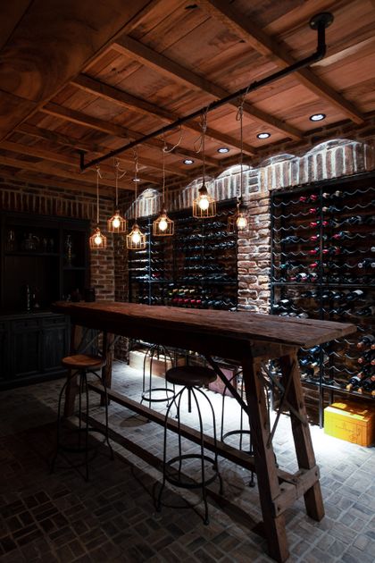 Bodega de vinos con barra madera, lámparas colgantes y ladrillo visto — proyecto Casa Toscana , por Estudio Du 