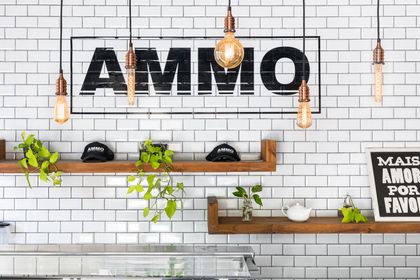 Local AMMO con pared de ladrillos blancos, estantes de madera y detalles industriales — proyecto Ammo Chic Food Company, por MARCO GUOLI PHOTO