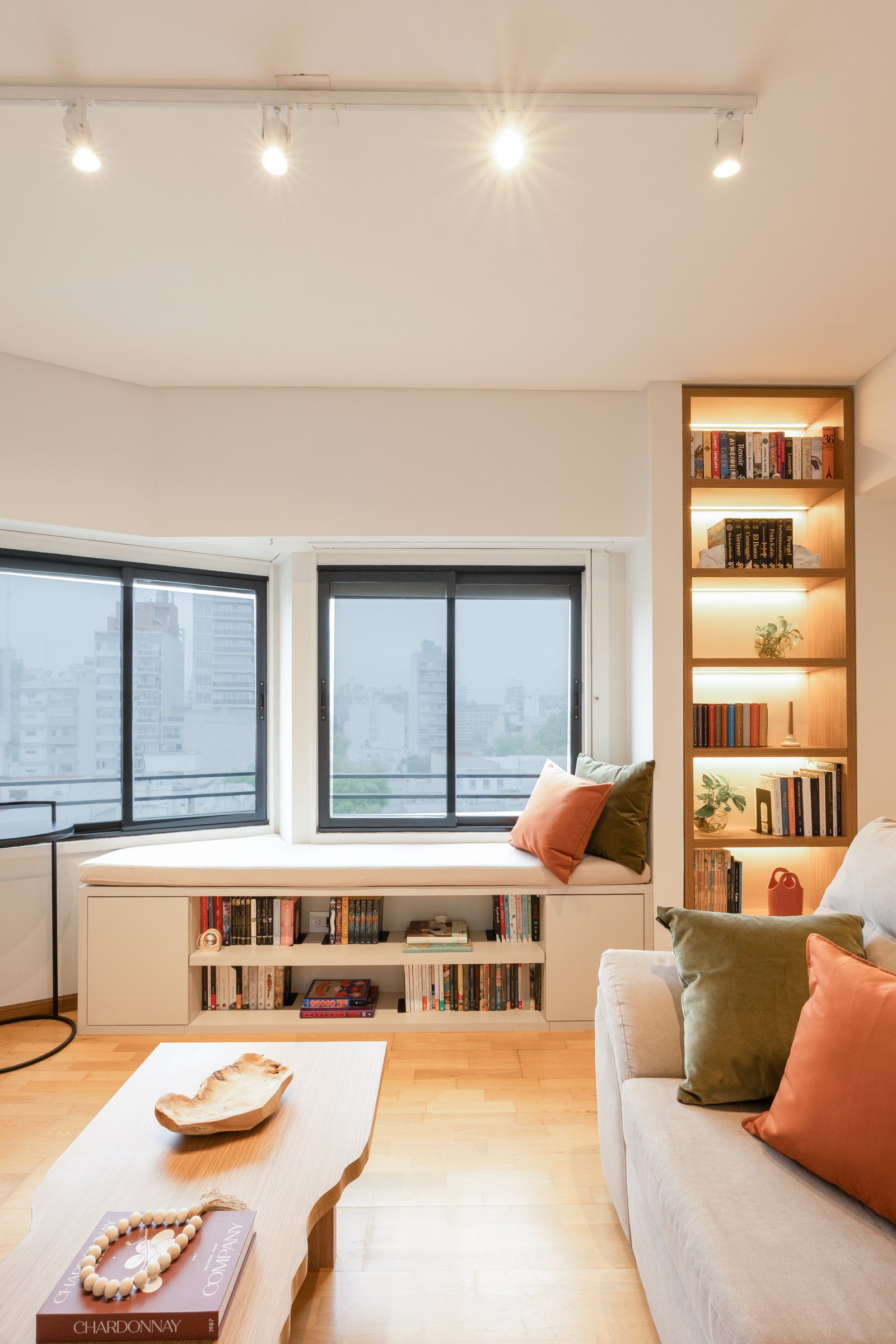 Living moderno con banco y biblioteca integrada — proyecto Rio, por Martina Kleinert, en Saavedra