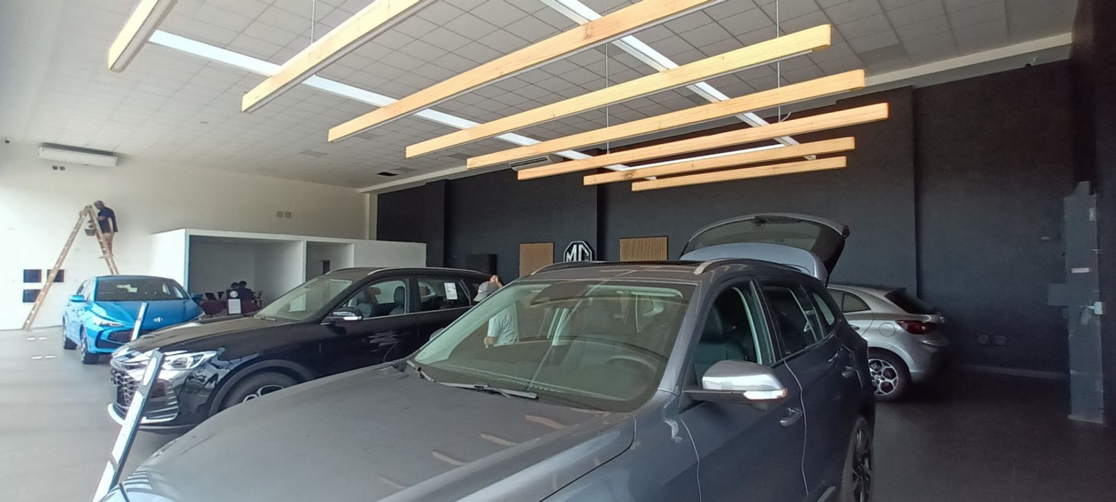 Showroom de autos en instalación con vigas de madera suspendidas — proyecto Locales Circunvalación Córdoba Norte, Indusplast Autocity, por Rojas Guri Arquitectos, en Córdoba