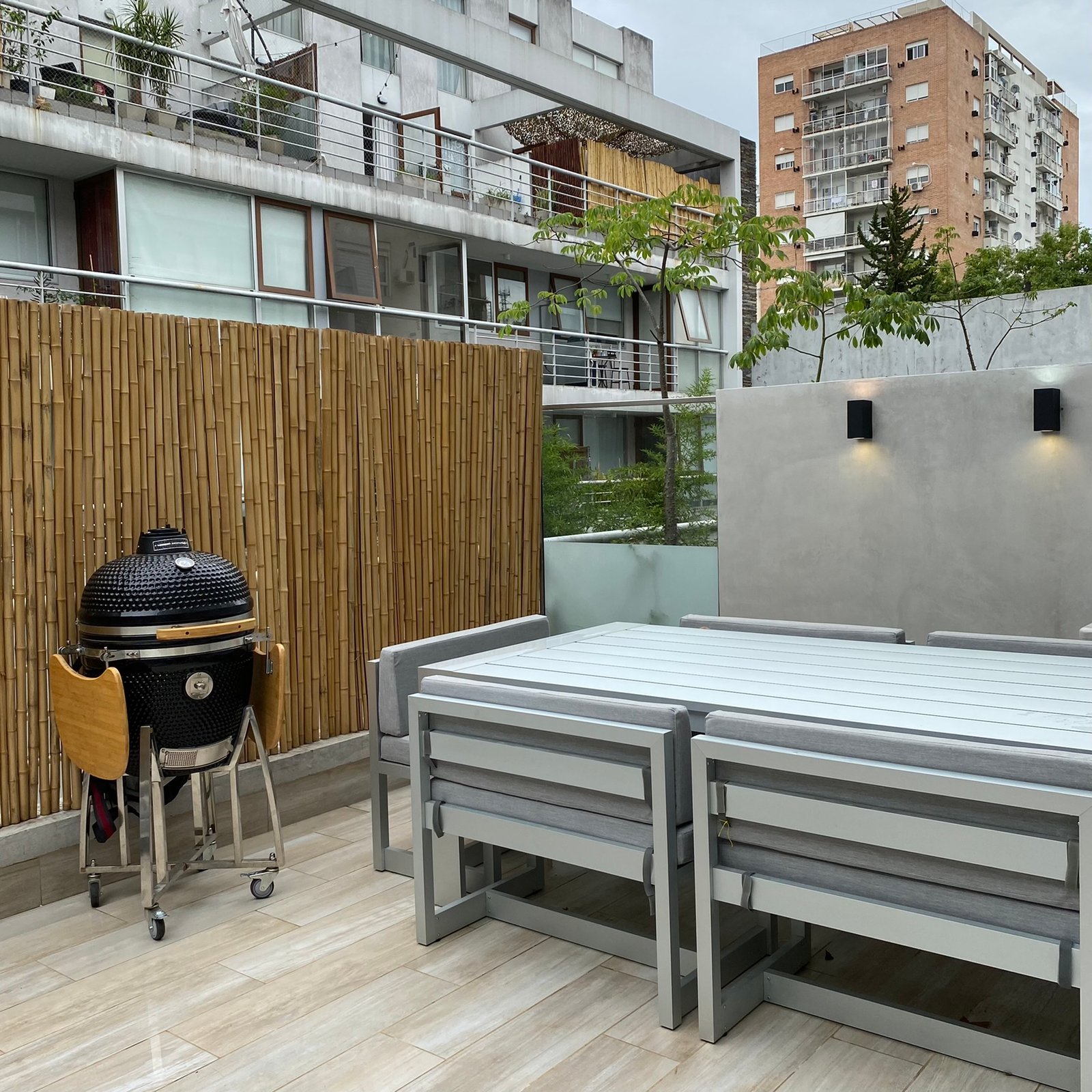 Quincho moderno con parilla kamado y juego de mesa exterior — proyecto Nicolas Repetto, por MDBK Arquitectura, en Caballito
