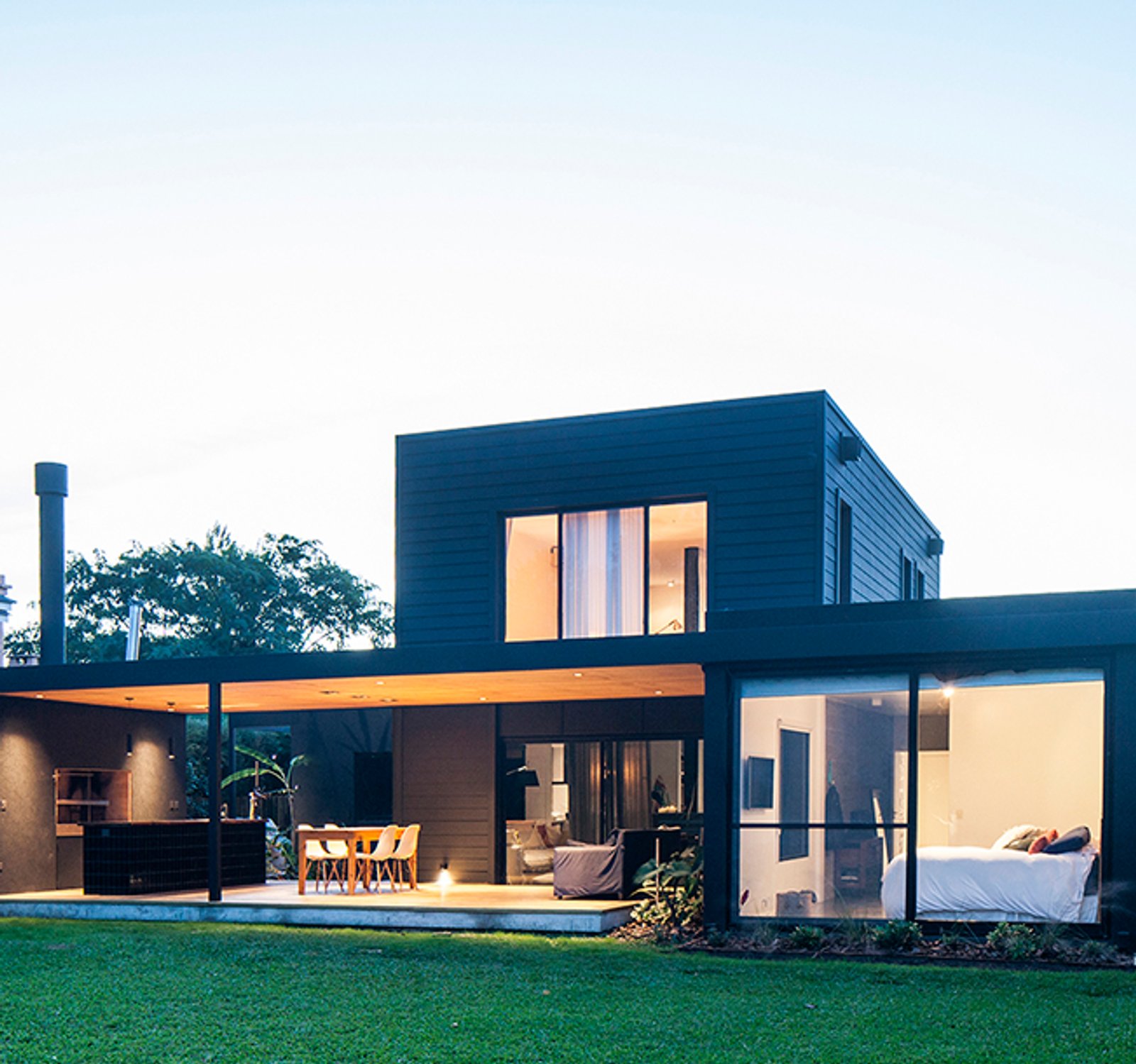 Fachada moderna de casa con detalles en madera y grandes ventanales — proyecto Casa coco, por Estudio PK, en B1648 Tigre