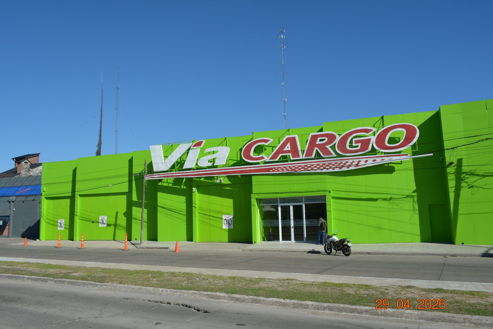 Fachada comercial verde brilhante da Via Cargo com sinalização — projeto Sucursal Via Cargo, filial Corrientes, Empresa de distribución y logística., por Arquitecto Gustavo Maidana