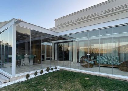 Galería contemporánea vidriada con jardín y deck integrado — proyecto BARRIO CARPINCHOS, NORDELTA, por CERRAMIENTOS PANORAMICOS, en Benavidez