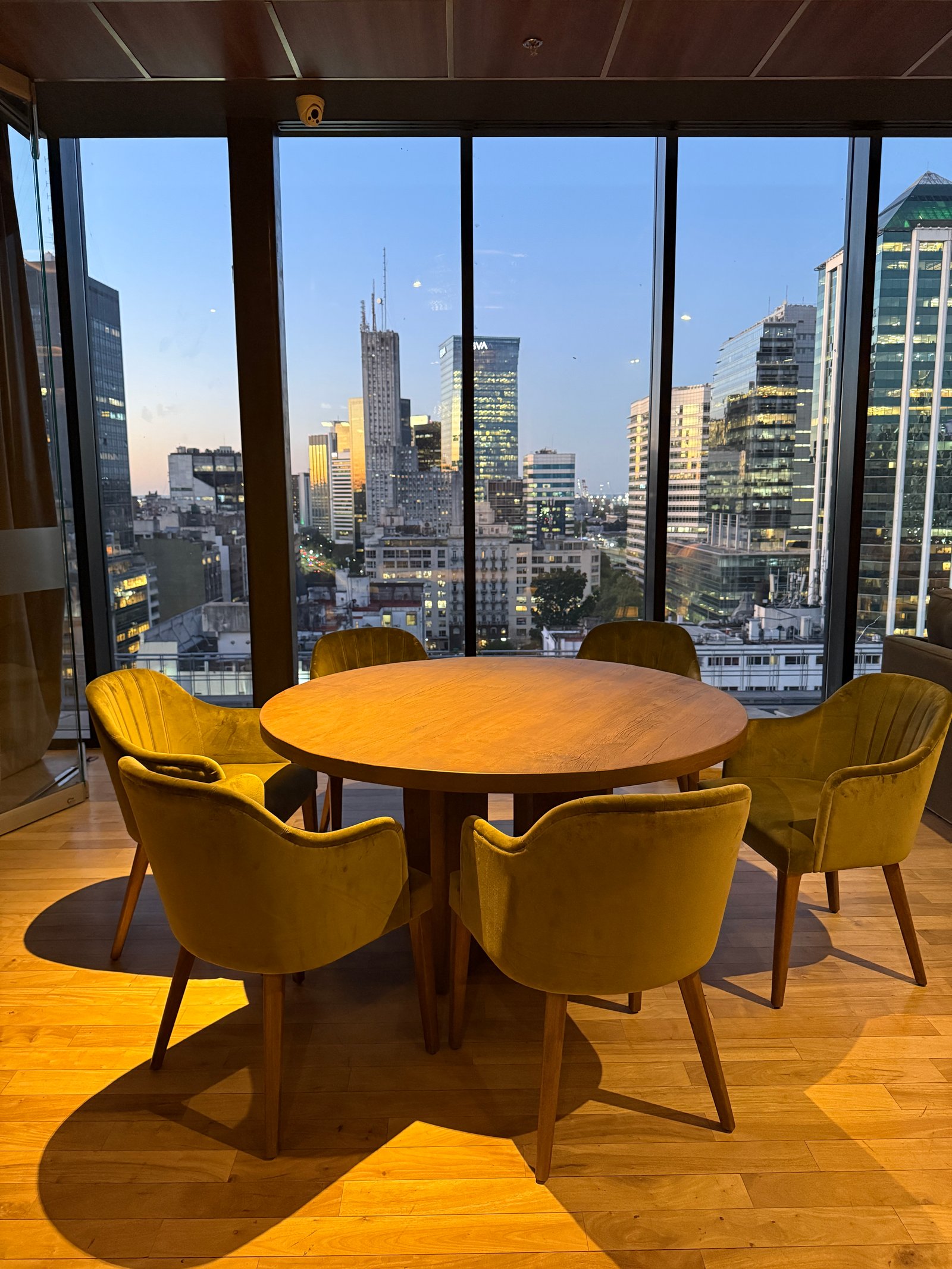 Comedor moderno con vista a la ciudad y sillas amarillas — proyecto Mirador Central, por Estudio Losa, en Sarmiento 151