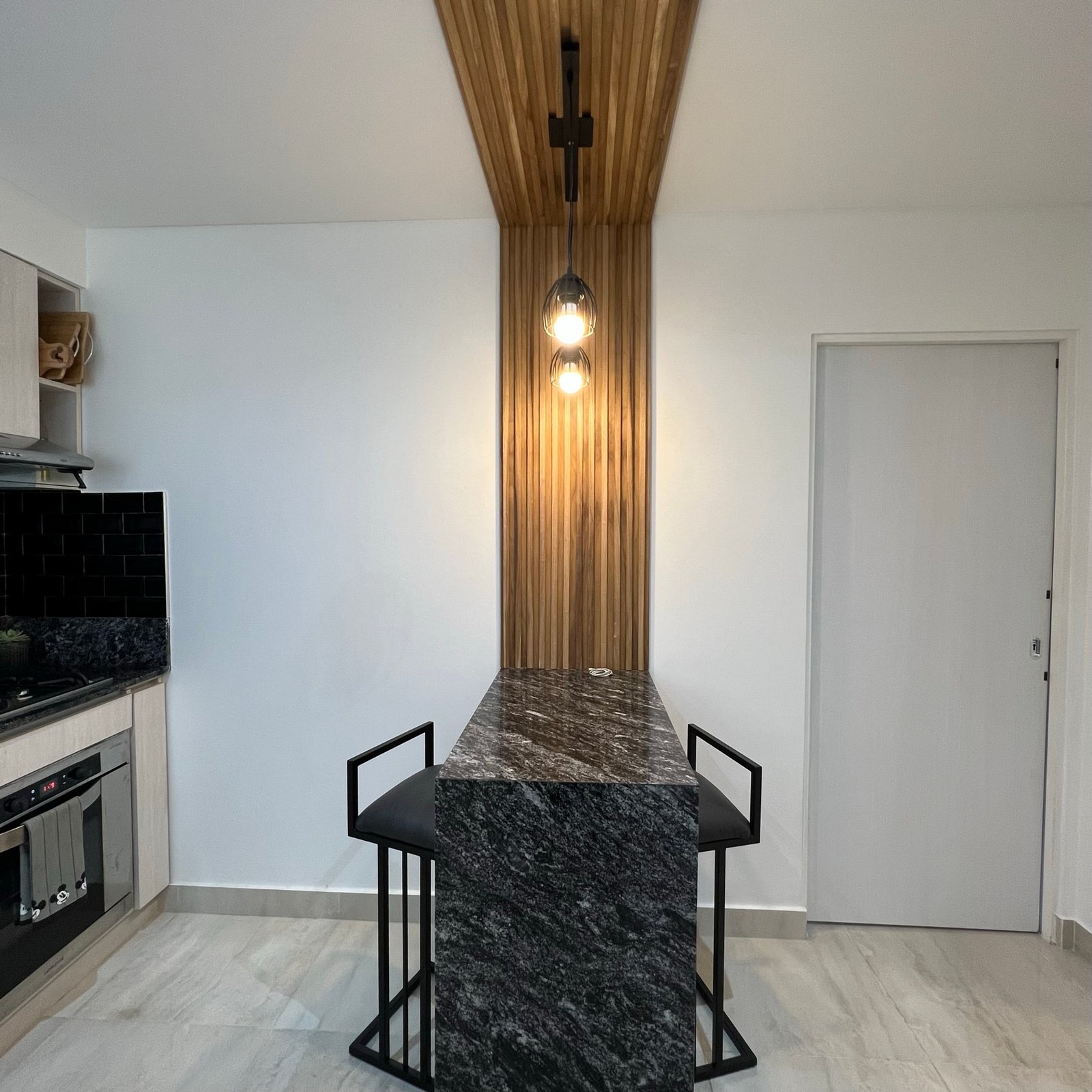 Cocina moderna con isla de mármol y techo de madera — proyecto Basualdo I, por MDBK Arquitectura, en Liniers