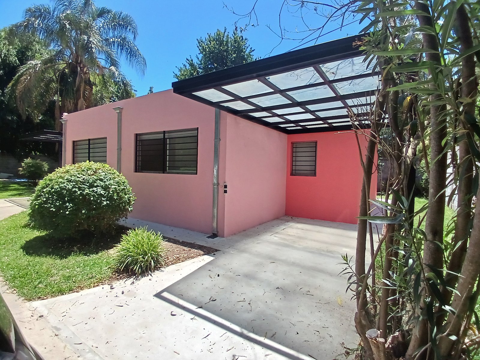 Fachada de casa moderna rosa con garaje de vidrio — proyecto Remodelacion de vivienda en Villa Elisa, La Plata, por Sep Arquitectura , en Villa Elisa