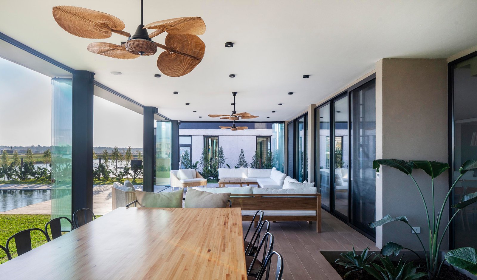 terraço coberto moderno com ventiladores de teto e vista para o jardim — projeto CASA C313, por A'PRIMA - Arquitectura Sustentable, em Provincia de Buenos Aires