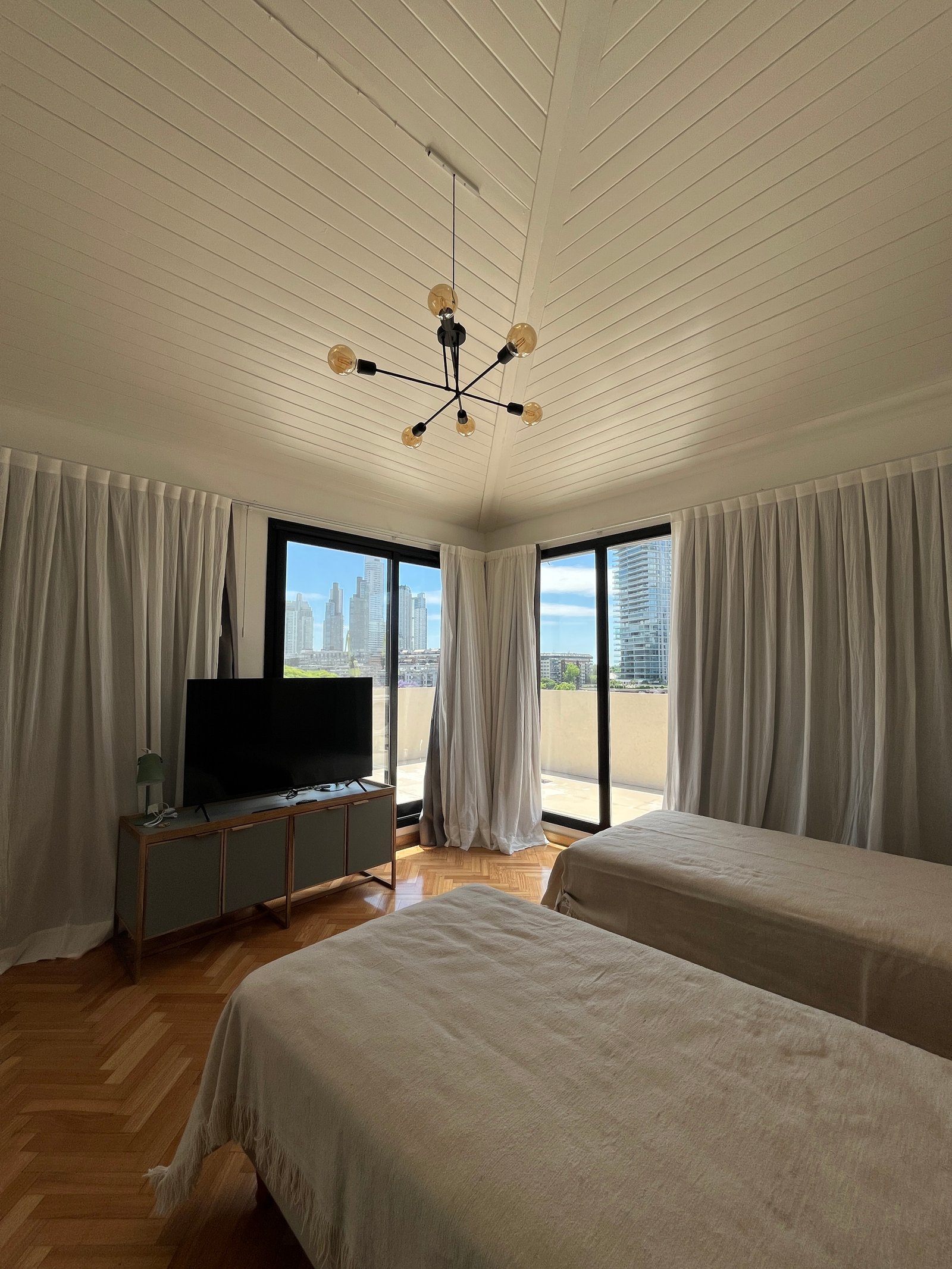 Dormitorio moderno con dos camas y techo de madera — proyecto Departamento Puerto Madero, por Arcucci Arquitectura, en Puerto Madero