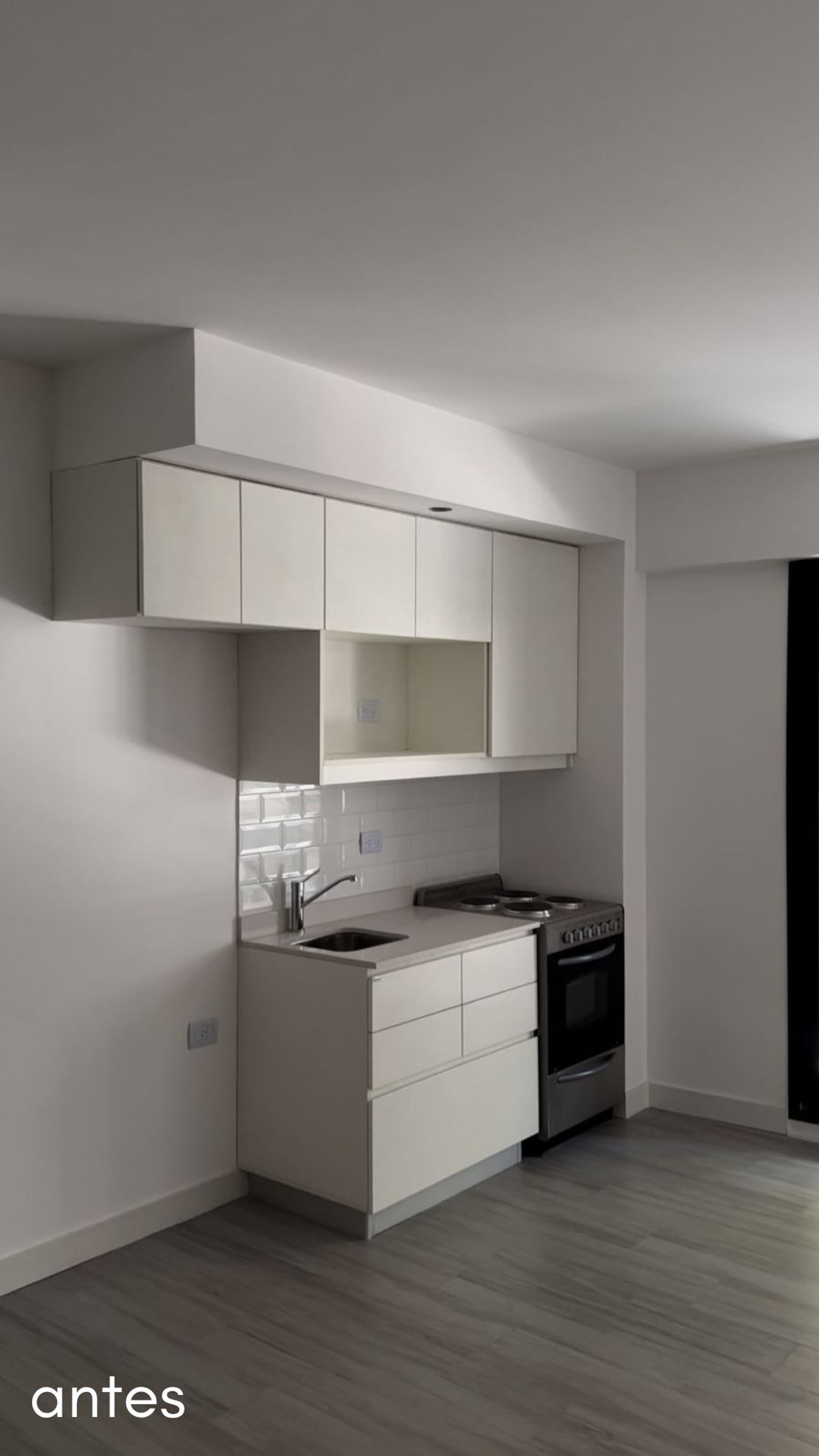 Cocina moderna y minimalista con gabinetes blancos y piso gris — proyecto Airbnb, por Estudio Hirsch, en Buenos Aires