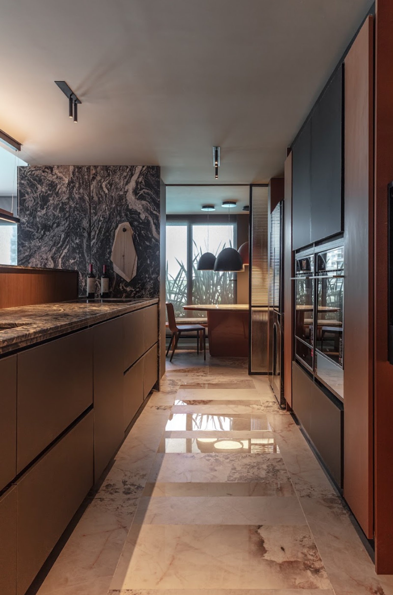 Cocina moderna con isla y comedor, revestimientos en mármol y madera oscura — proyecto Adriana Randazzo, por San Lorenzo Design, en Cam. de los Remeros 1585