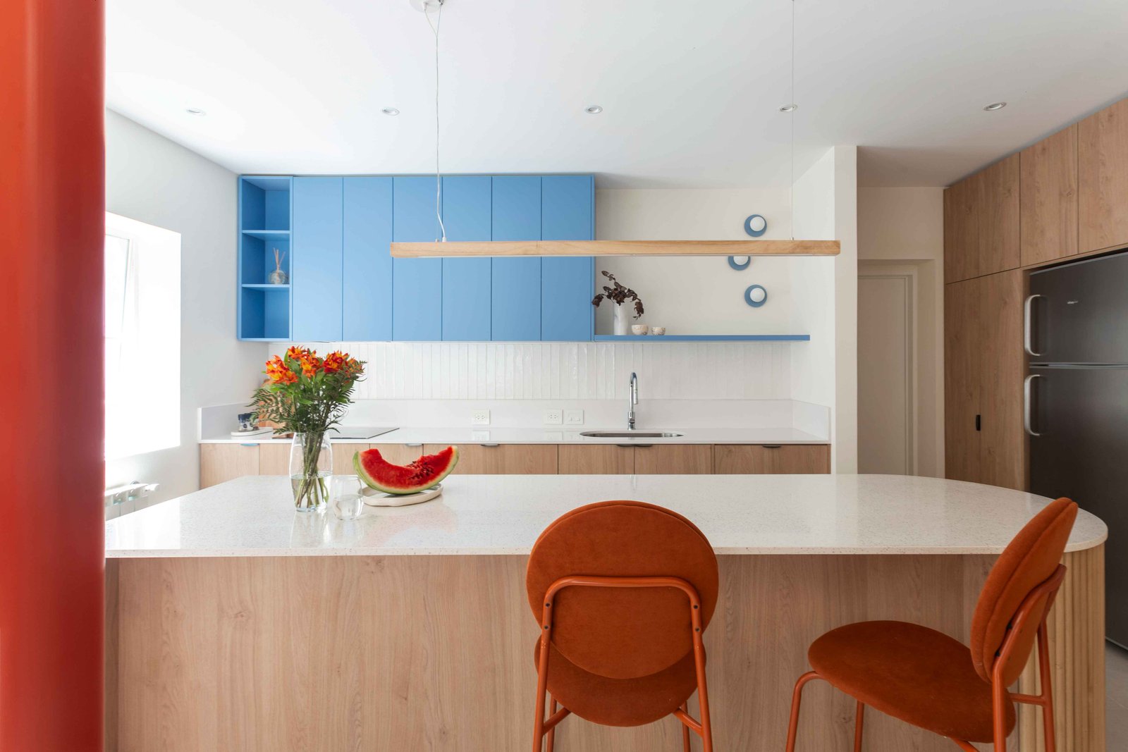 Cocina moderna con isla central y muebles celestes — proyecto Grecia, por Bouré Studio, en Núñez