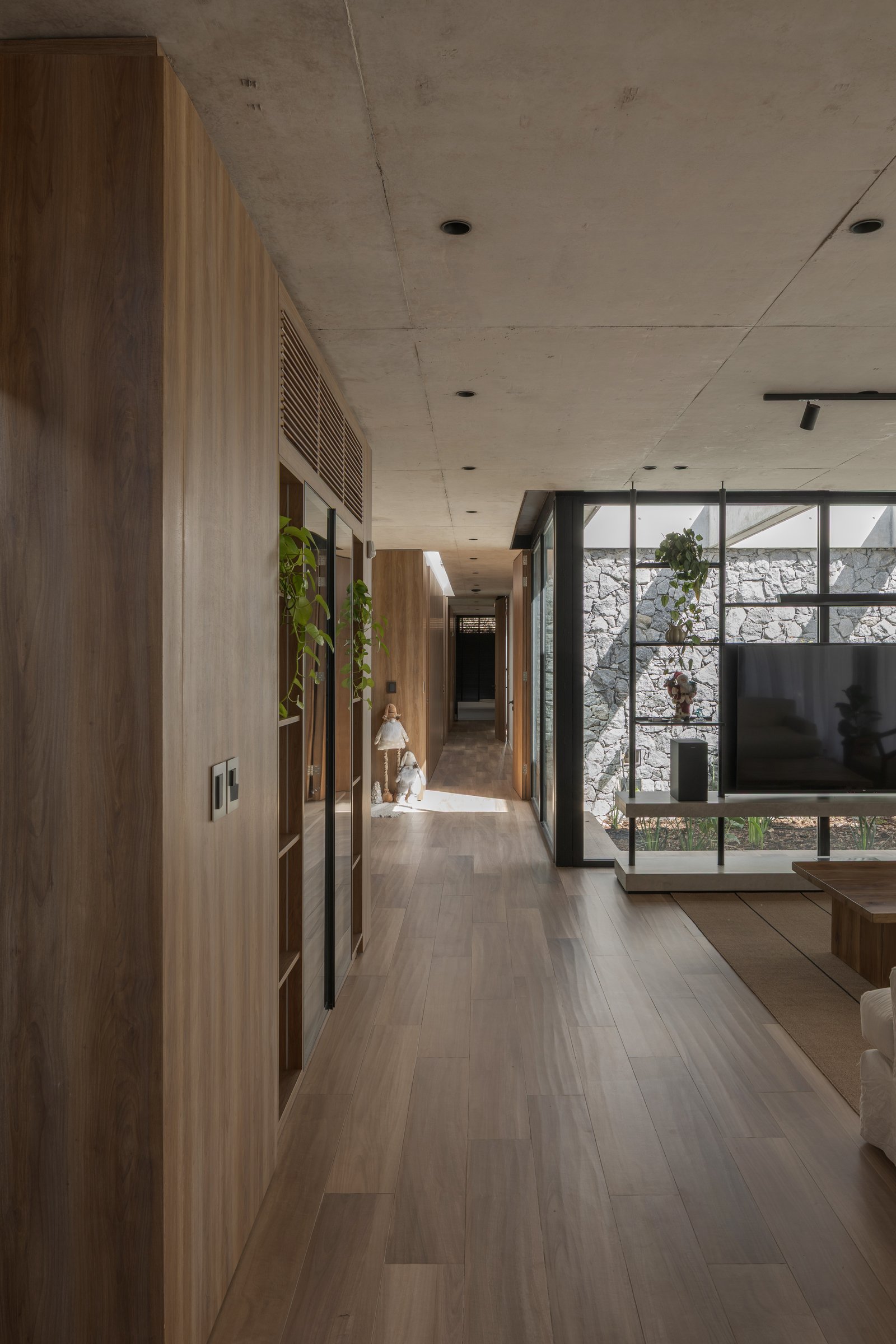 Pasillo moderno con revestimiento de madera y techo de hormigón — proyecto Casa PLANALTO, por Grupo CRBN, en Av. Pres. Perón 10298