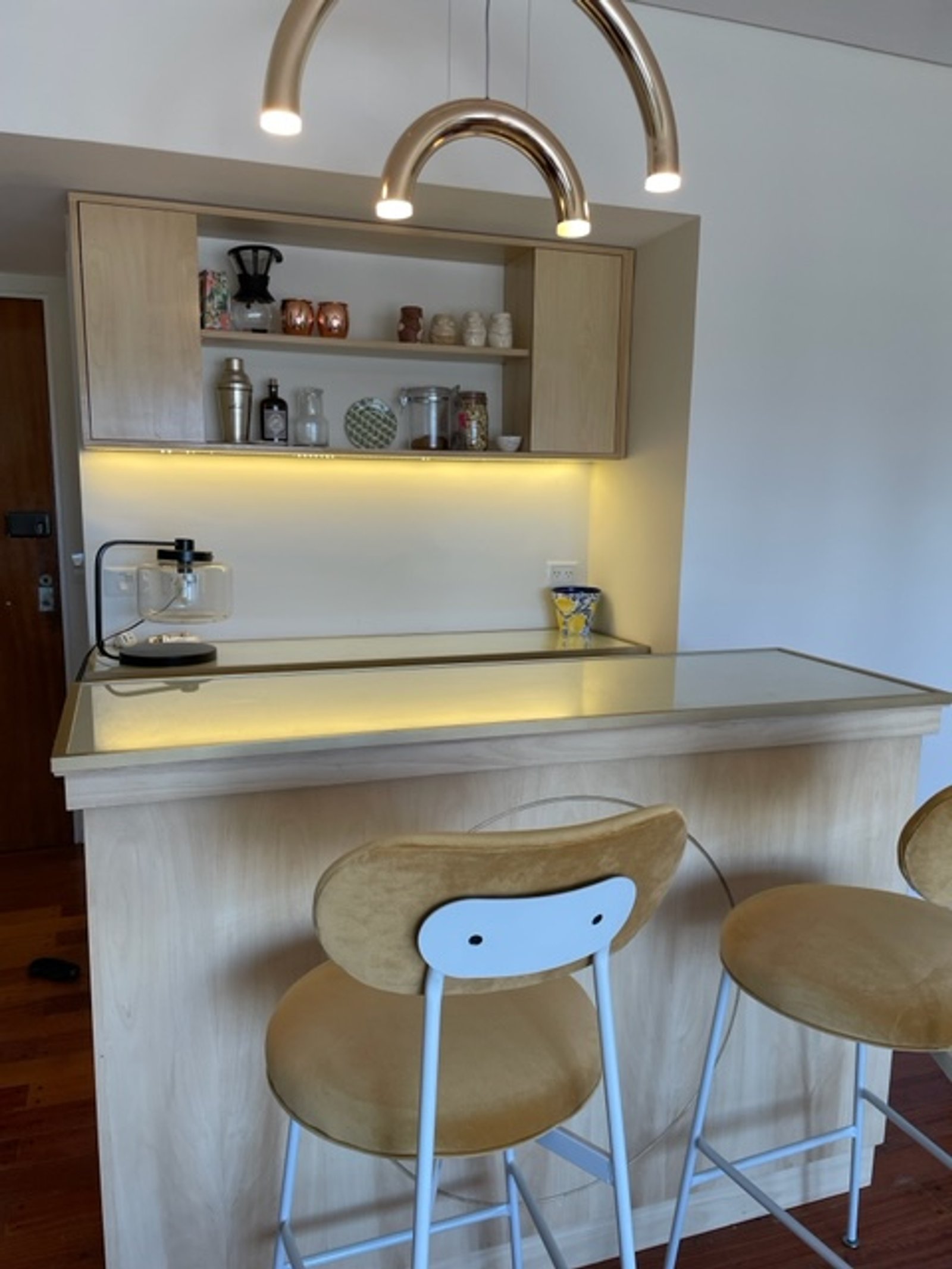 Cozinha moderna com balcão e banquetas de veludo amarelo — projeto Chenaut, por Estudio NET Arquitectura, em Av. Gral. Indalecio Chenaut 1739