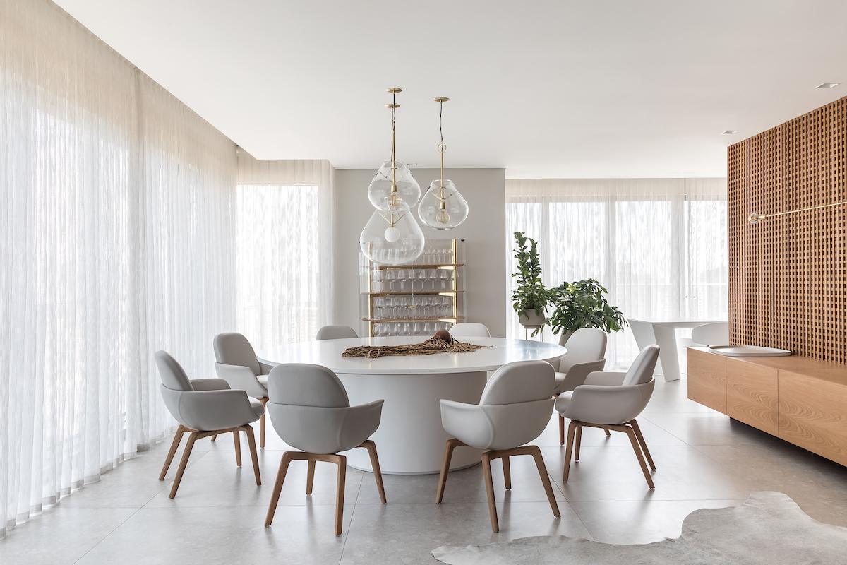 Sala de jantar moderna com mesa redonda e cadeiras curvas — projeto Apto | EBS, por Claudia Vialle Arquitetura, em Caçador