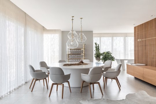 Living y comedor moderno con mesa redonda y sillas grises — proyecto Apto | EBS, por Claudia Vialle Arquitetura, en Caçador