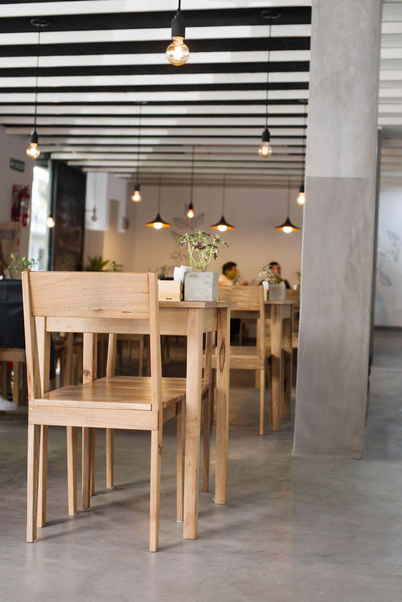 Sala de jantar moderna com teto listrado e luzes industriais — projeto CHEILE - Cafe&Restó, por GALPON OSUNA, em Buenos Aires