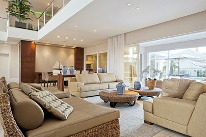 Sala de estar moderna y espaciosa con sofás grandes y suelo de madera — proyecto Casa Ponta Grossa, por ARQUITETARE POR ELAINE ZANON & CLAUDIA MACHADO