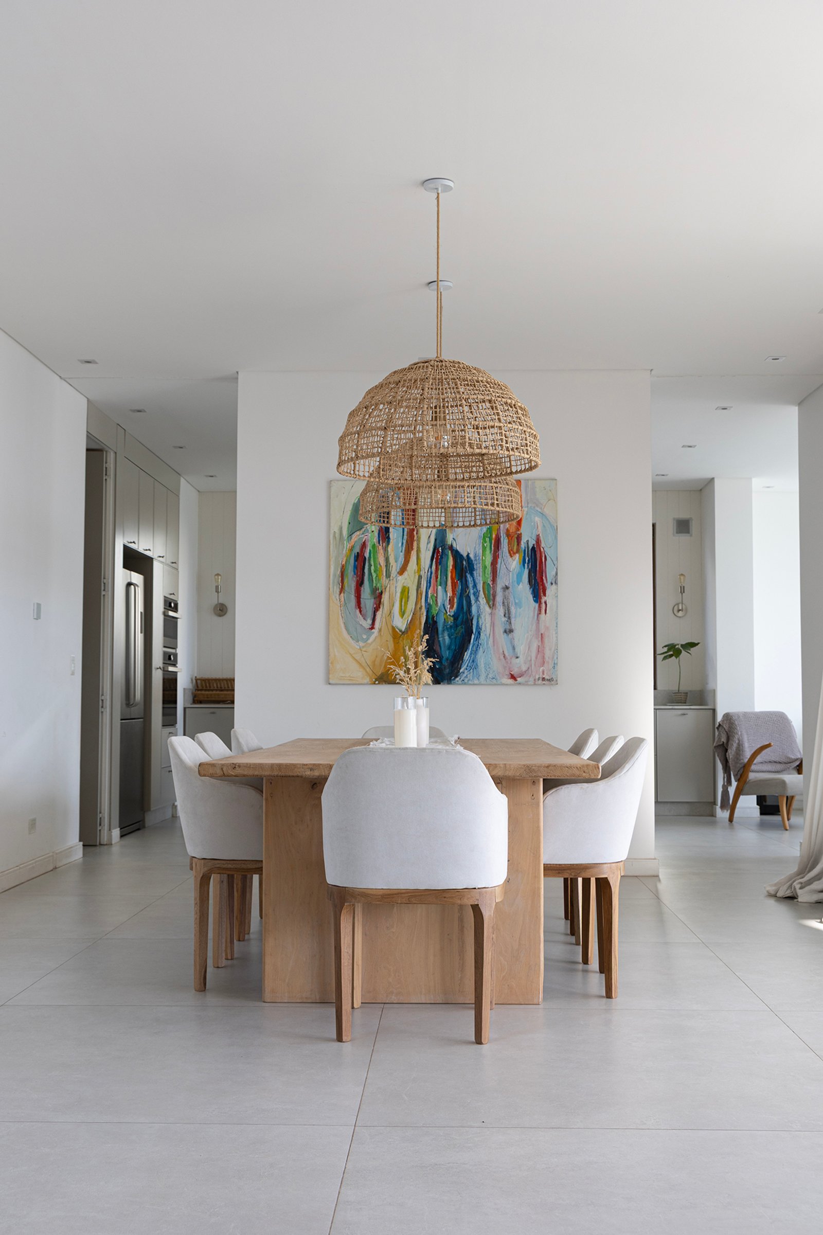 Comedor moderno con arte abstracto y lámpara de mimbre — proyecto Casa Al Agua - Grupo PAUTA, por Gaby Alfonso, en Belén de Escobar