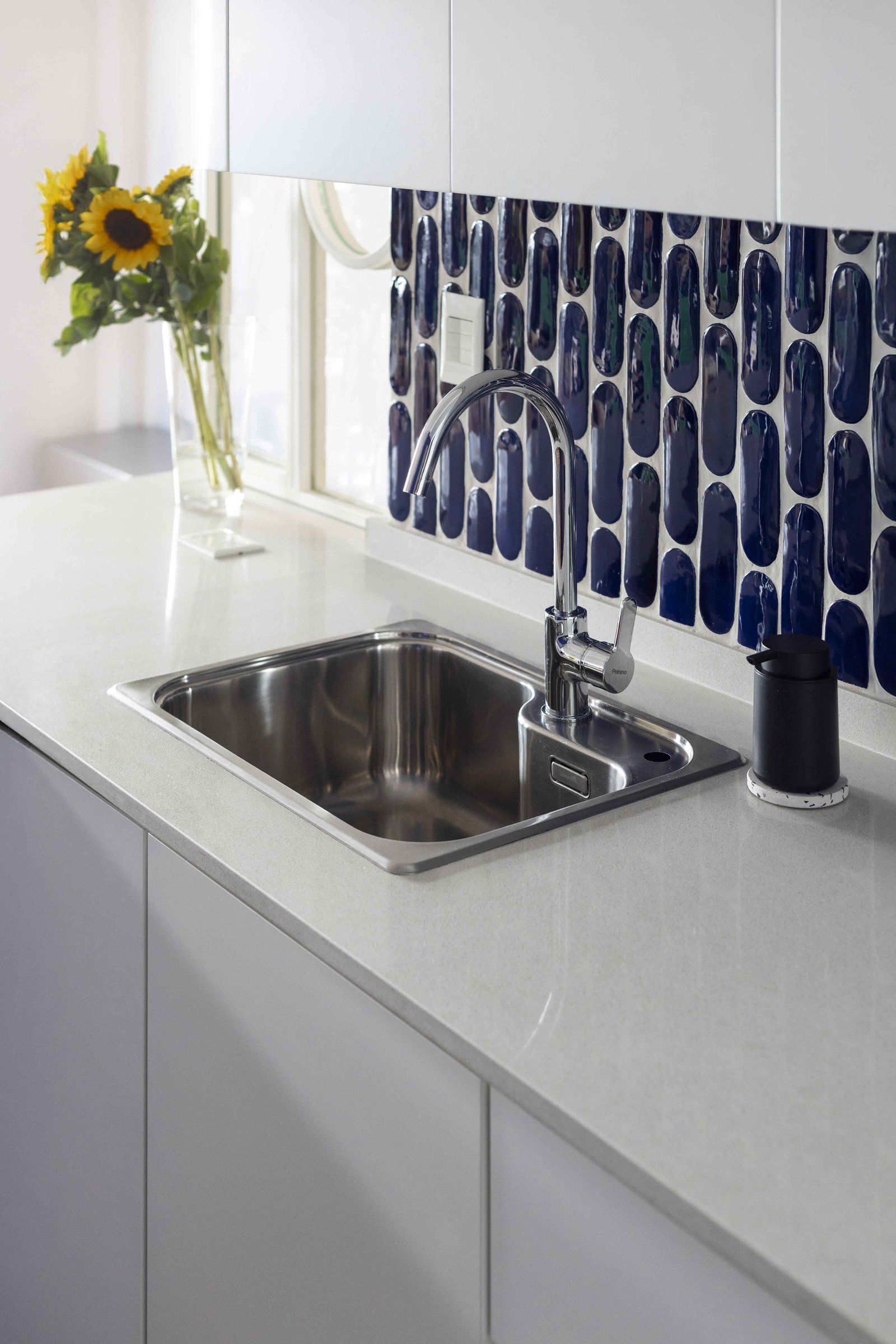 Cozinha moderna com backsplash de azulejo azul e bancada de pedra — projeto Julián Alvarez, por Bouré Studio, em Palermo
