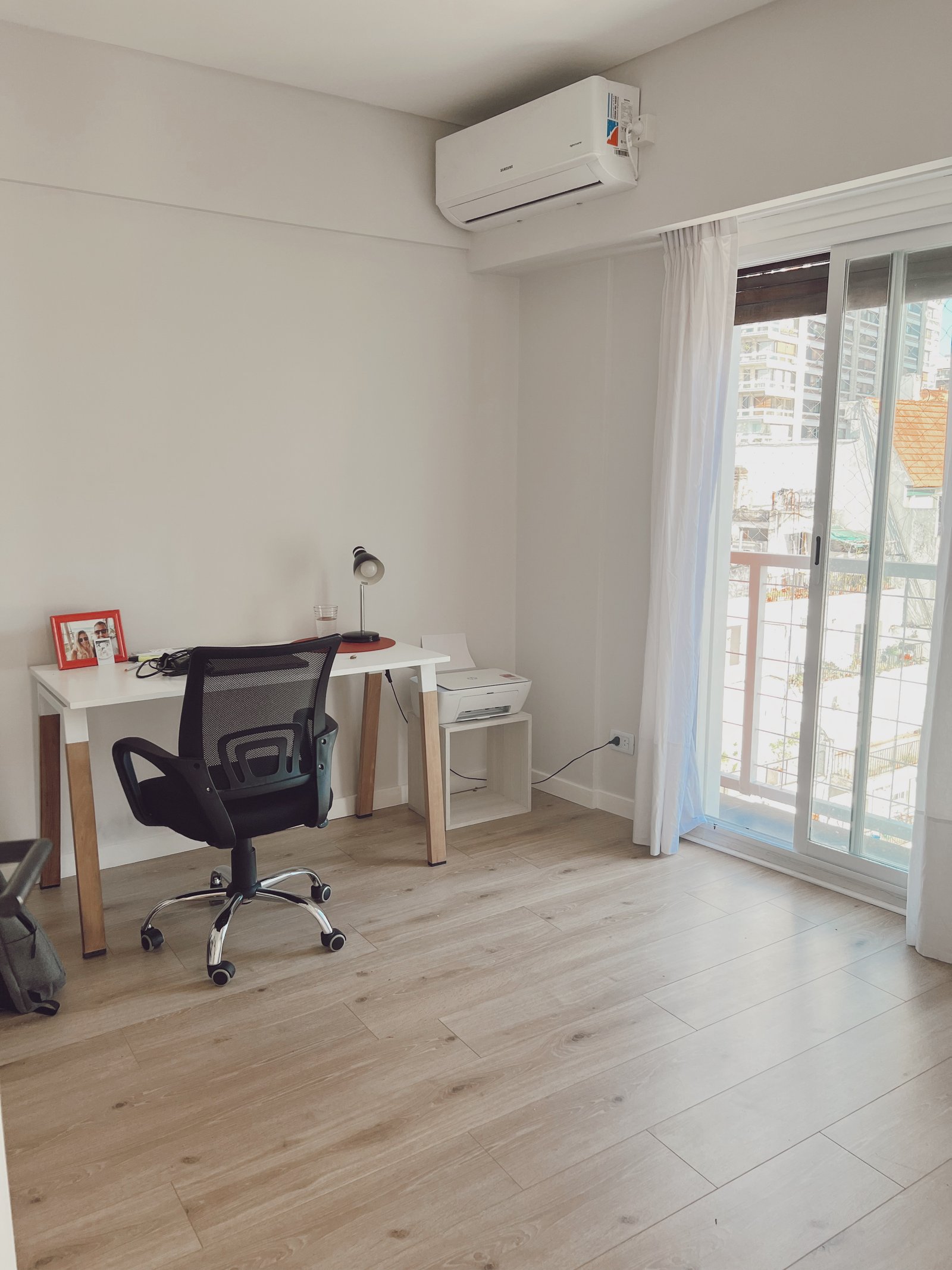 Oficina moderna con escritorio blanco, silla negra y gran ventana — proyecto Juncal, por Equipe, en Buenos Aires