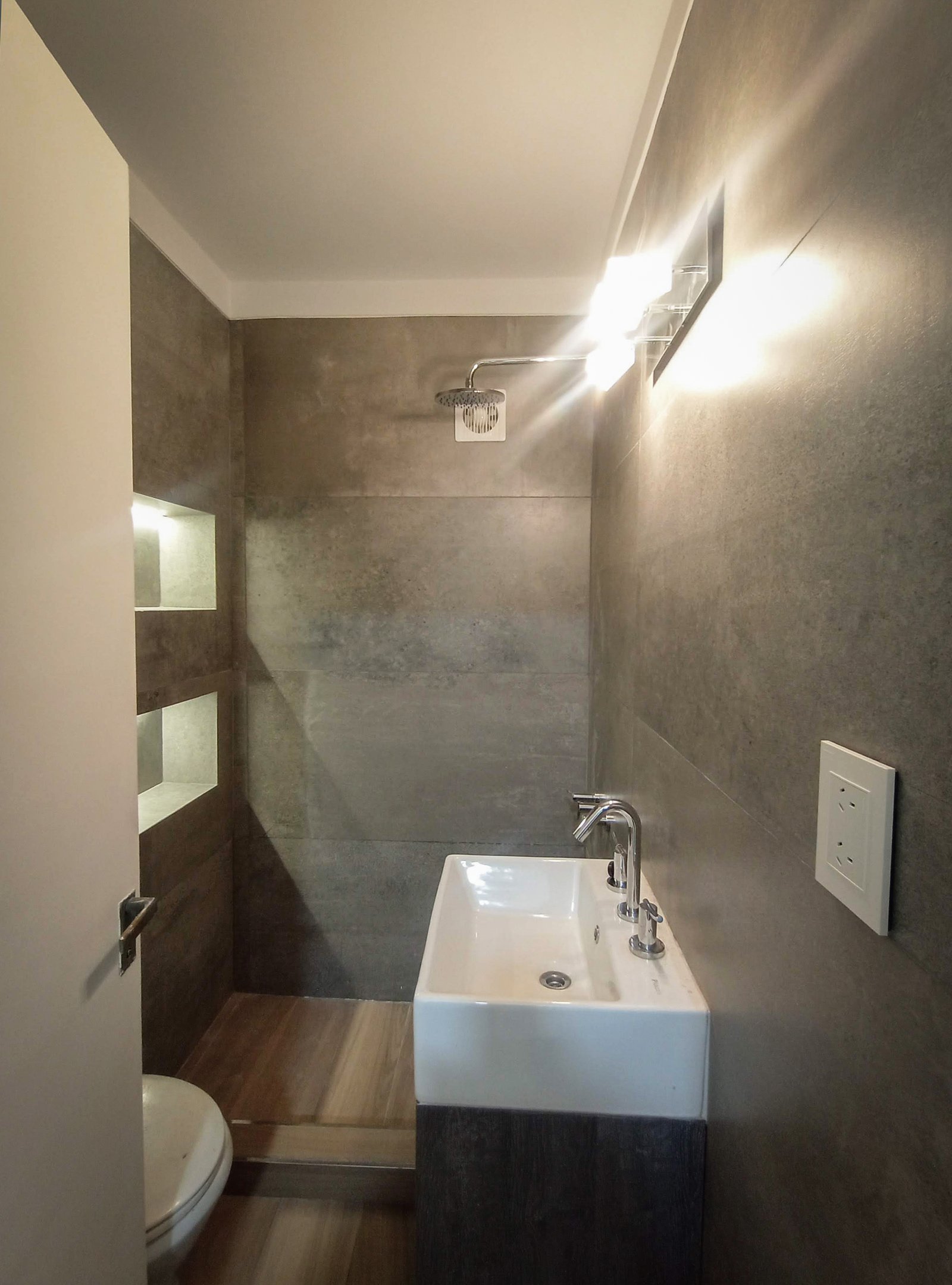 banheiro moderno com paredes de microcimento e madeira — projeto PH Beruti, por ASIA - arquitectura, em Palermo