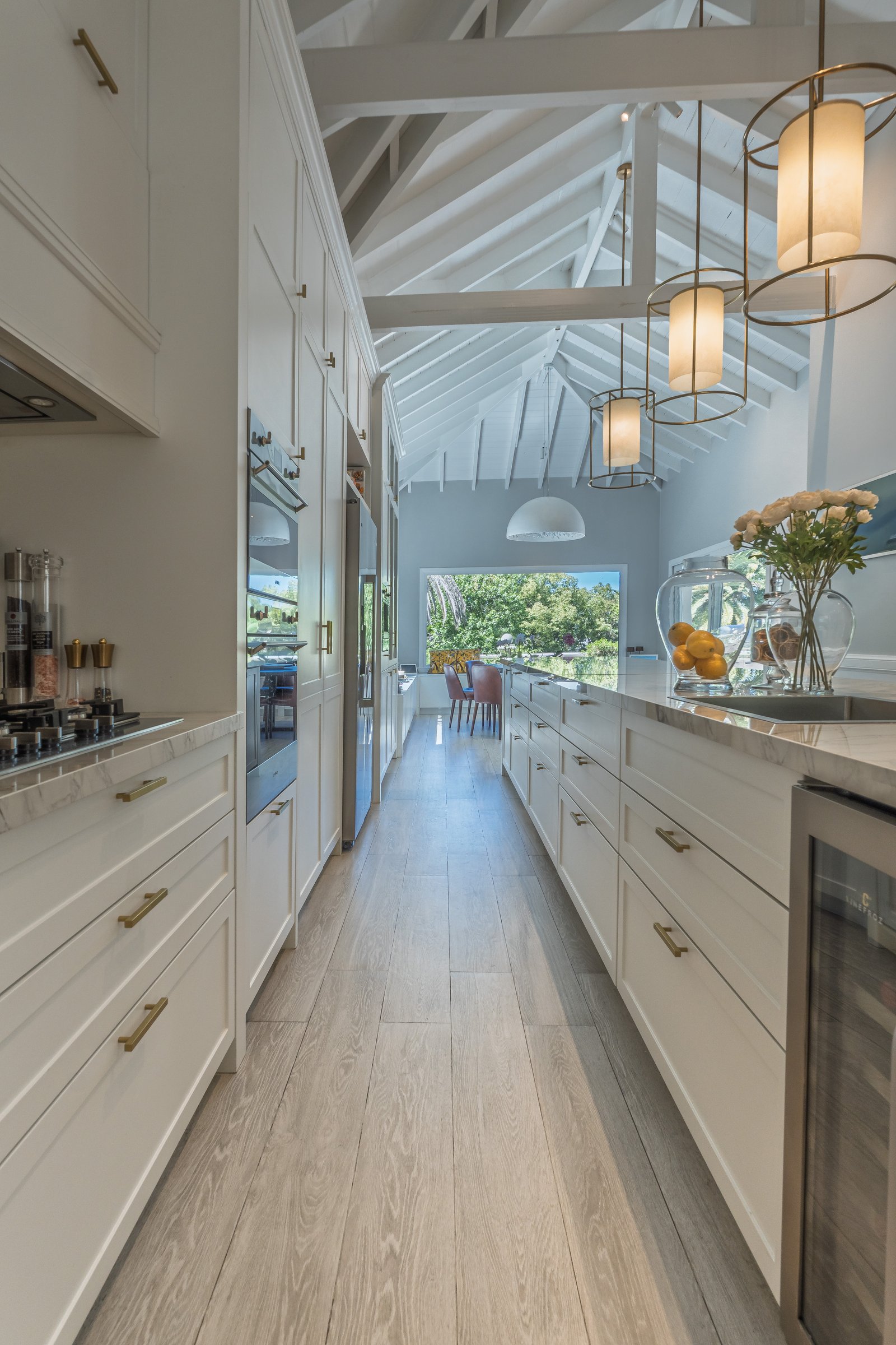 Cocina moderna con vigas expuestas y gran ventanal al campo — proyecto Talar de Pacheco, por ABEJA CONCEPT, en Gral. Pacheco